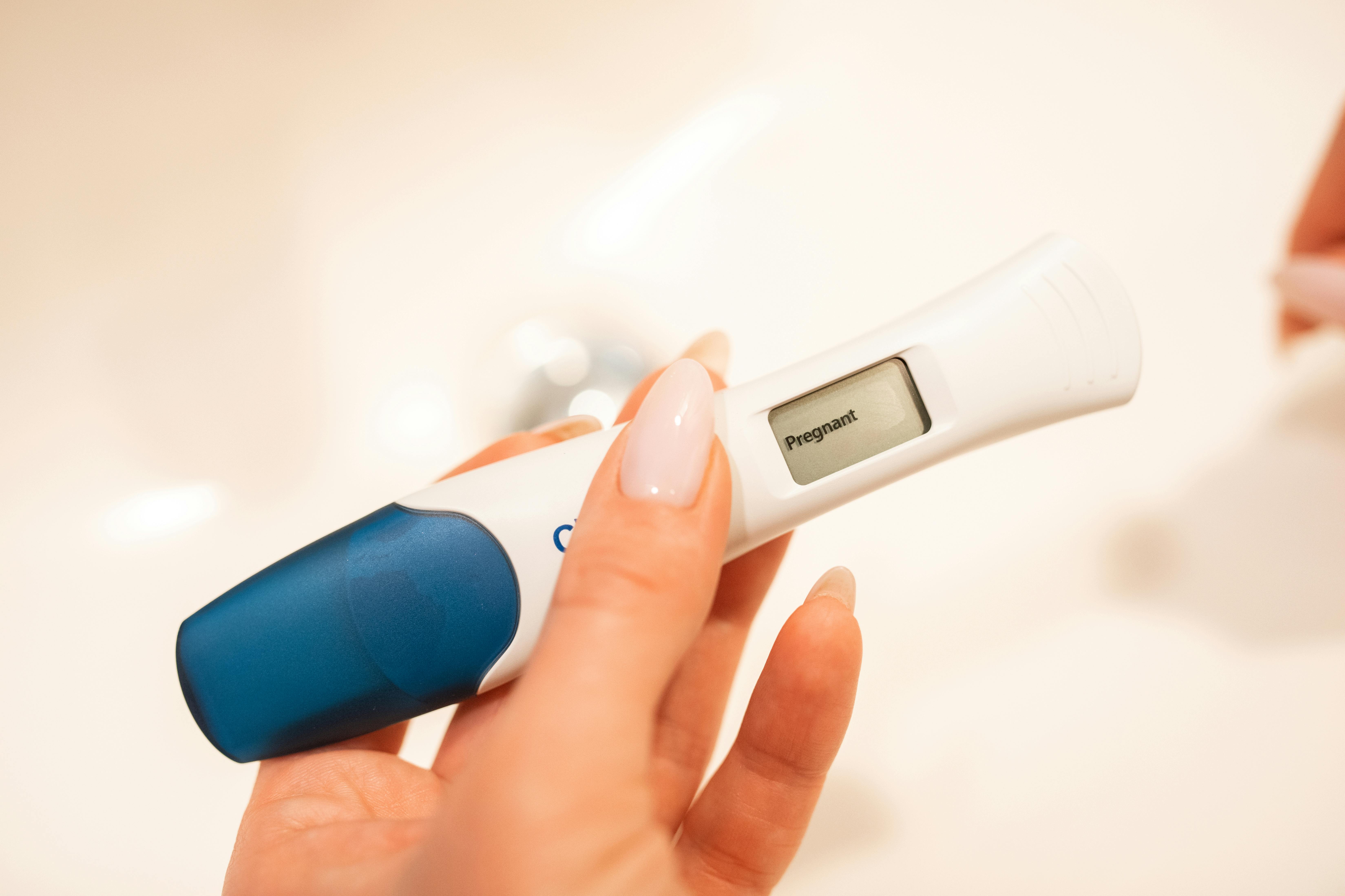A woman holding a positive pregnancy test | Source: Pexels