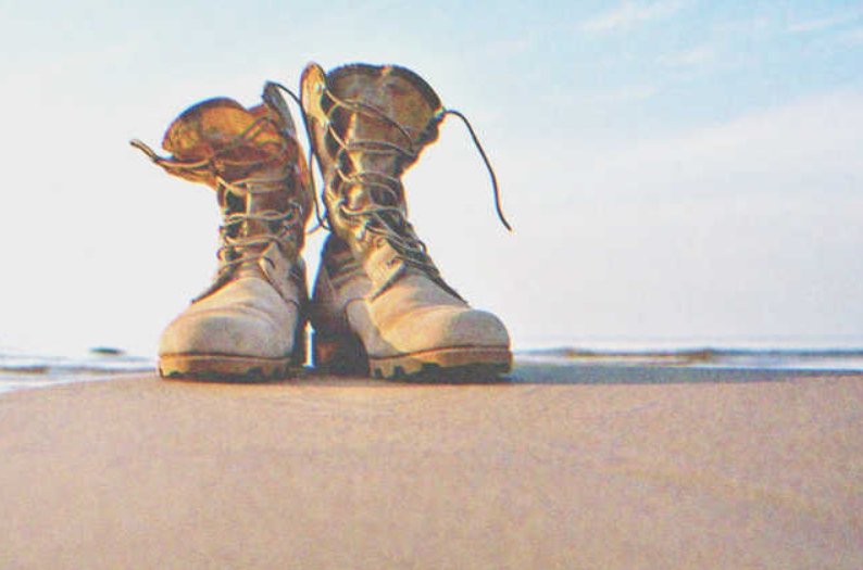 Pair of military boots on the beach |Source: Shutterstock