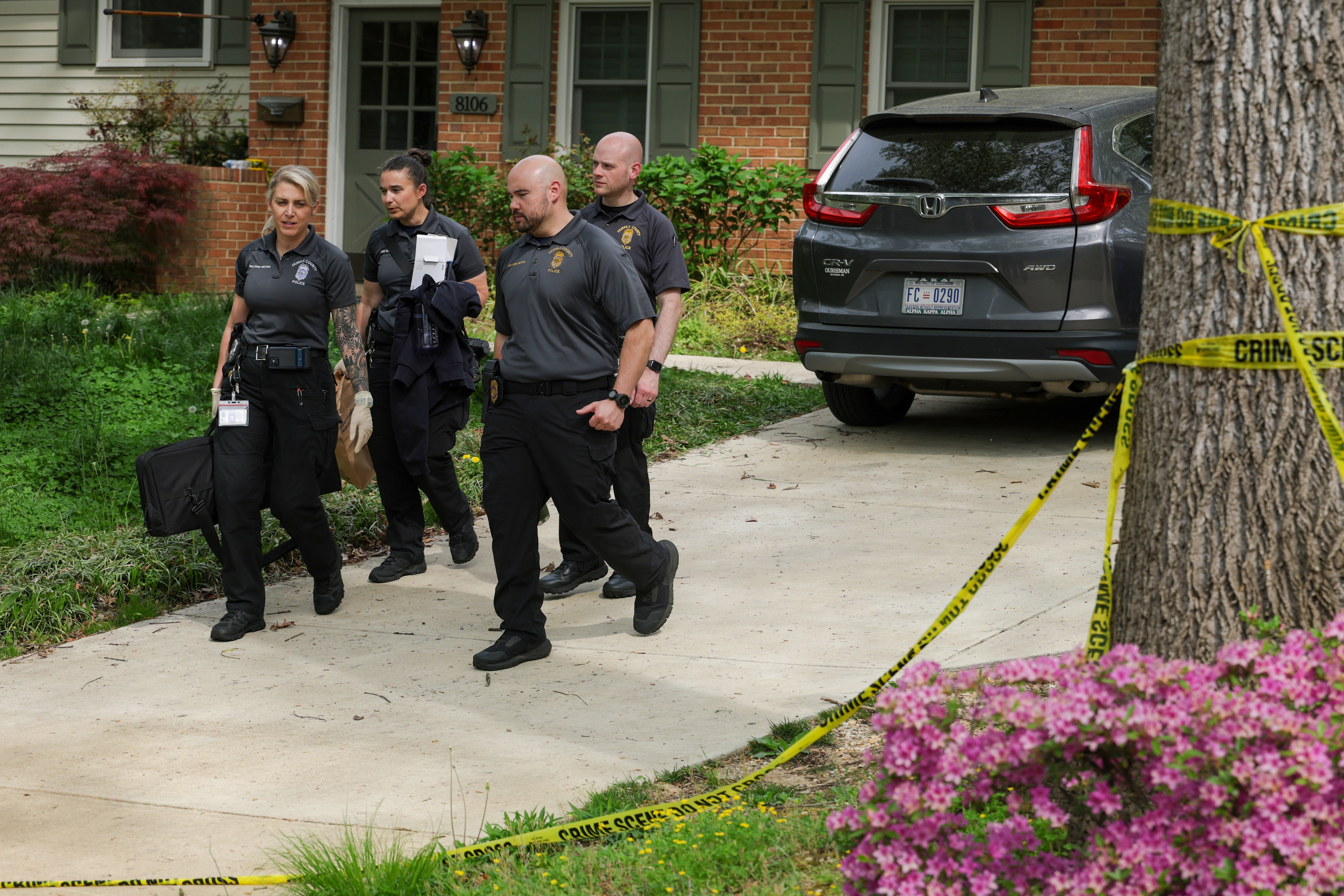 A group of investigators walks along the driveway carrying collected materials from the home in Annandale, Virginia on April 16, 2026 | Source: Getty Images