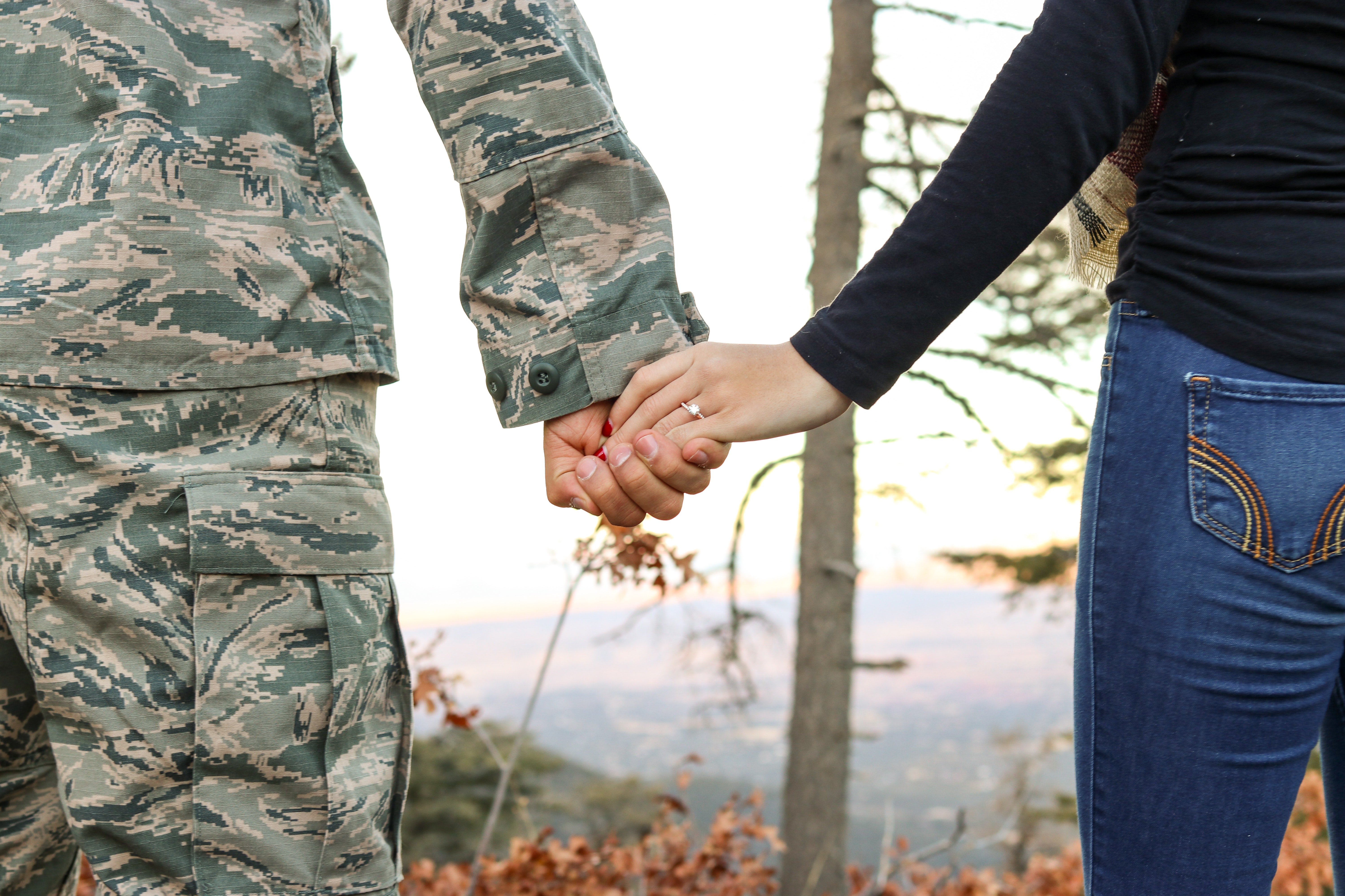 Hombre en uniforme de soldado de la mano de una mujer. | Foto: Pexels