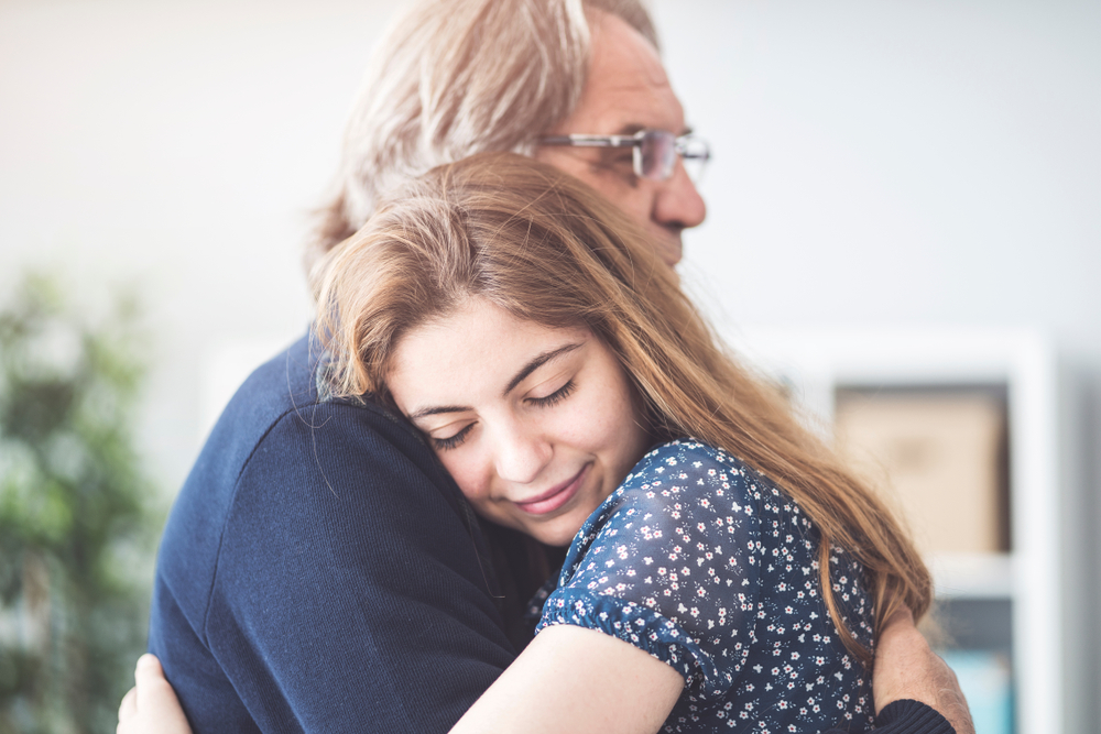 A young girl hugging her father tightly | Source: Shutterstock
