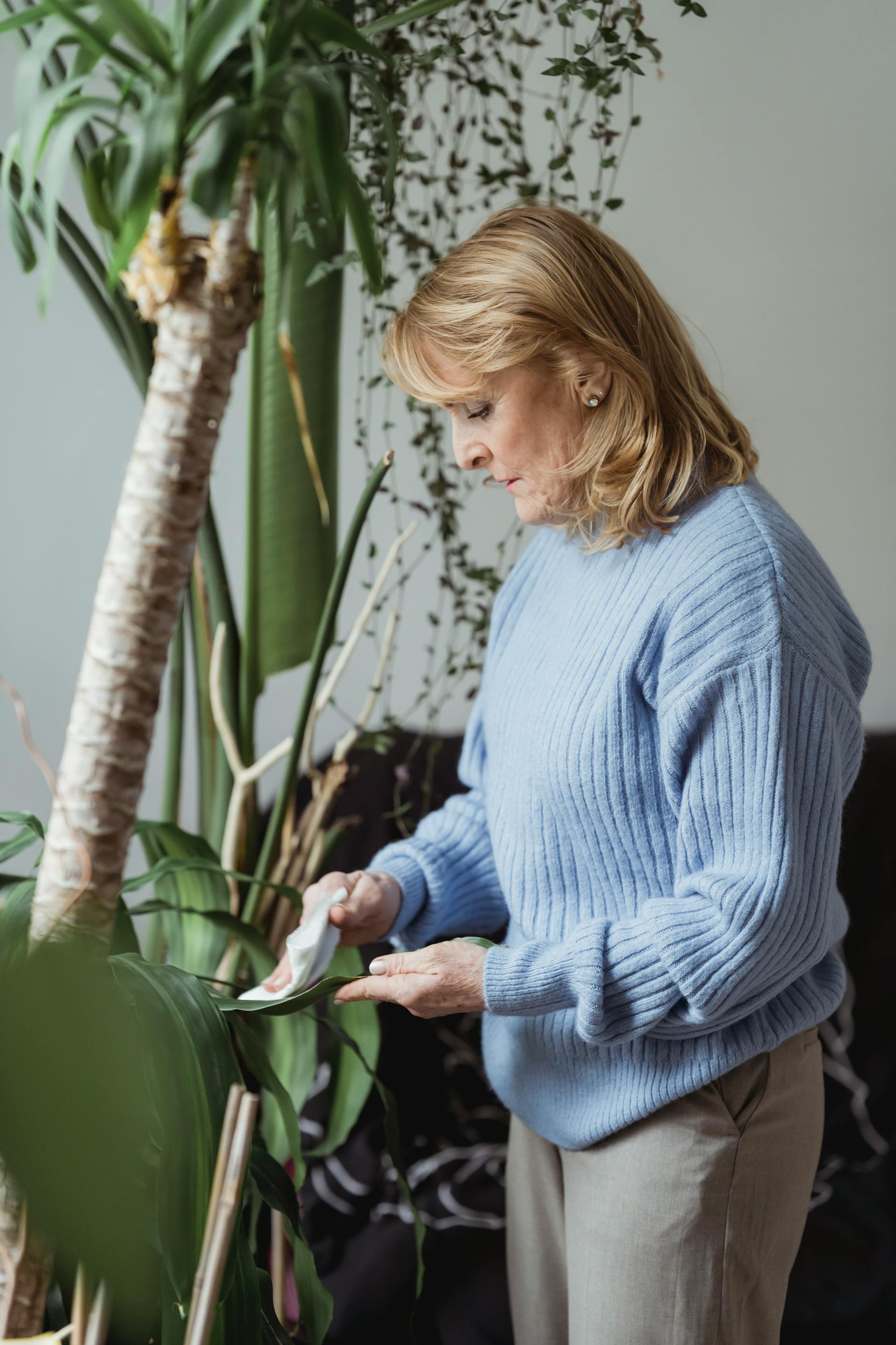 An older woman tending to plants | Source: Pexels