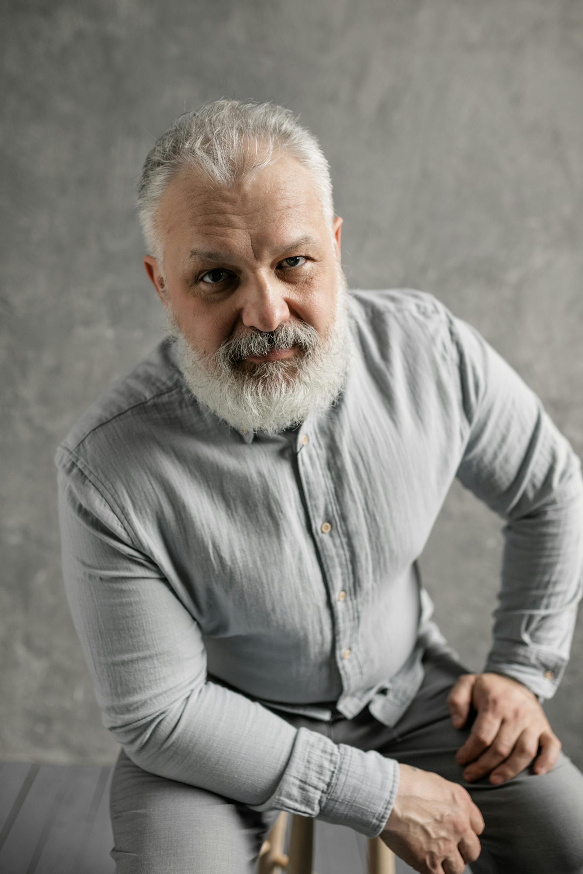 A serious-looking man sitting on a chair | Source: Pexels