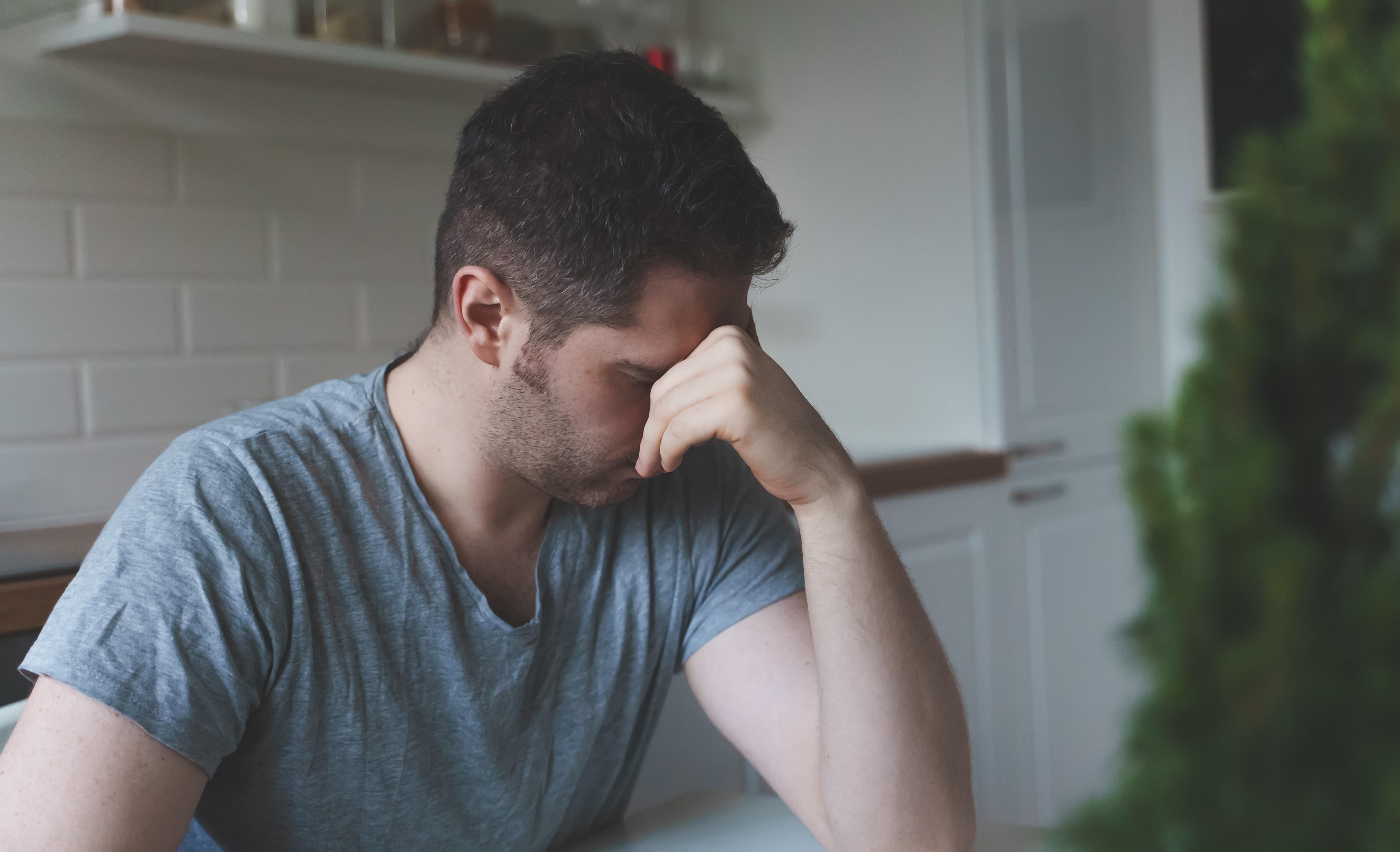 An upset man sitting in the kitchen | Source: Shutterstock