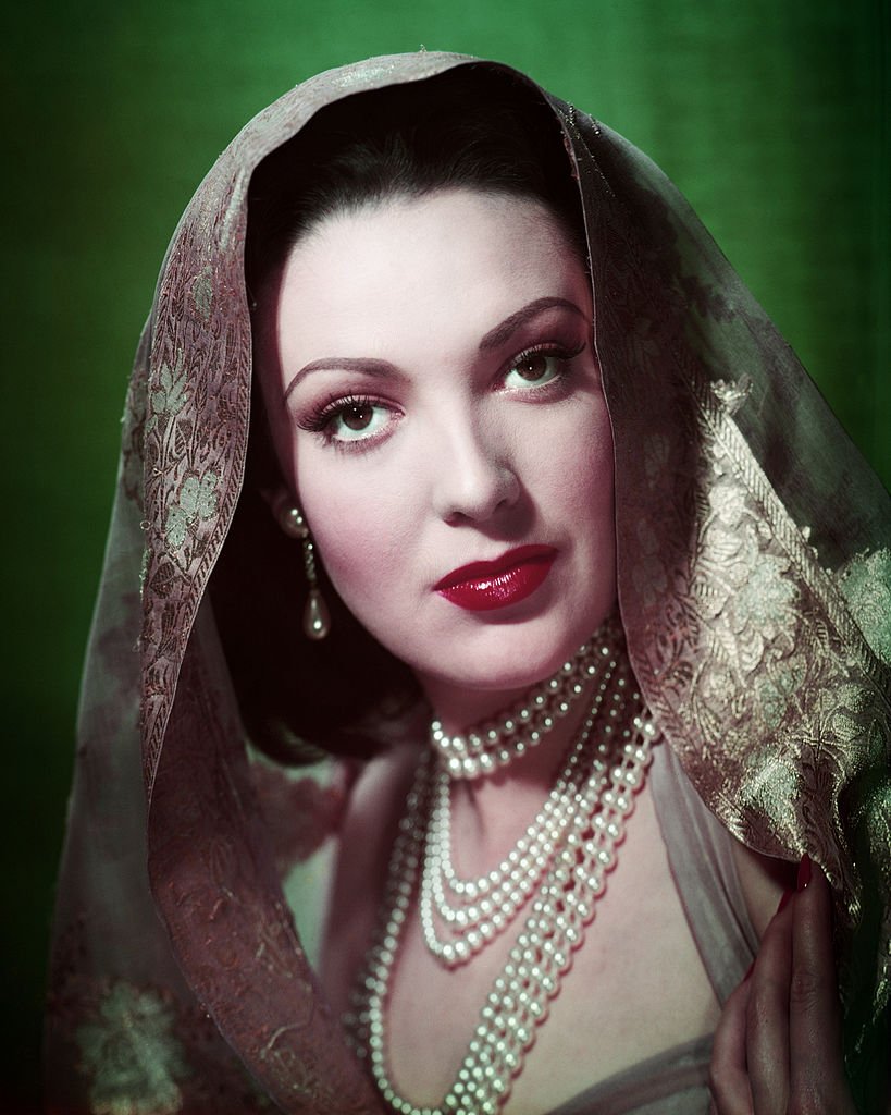 Portrait of American actress Linda Darnell wearing a headscarf and three pearl necklaces, circa 1950. | Photo: Getty Images