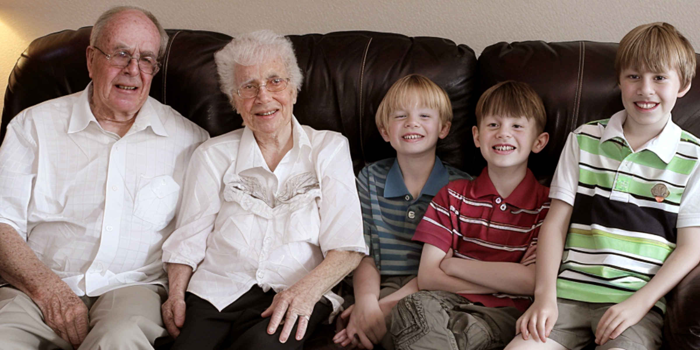 Grandparents and grandchildren sitting on a couch | Source: AmoMama