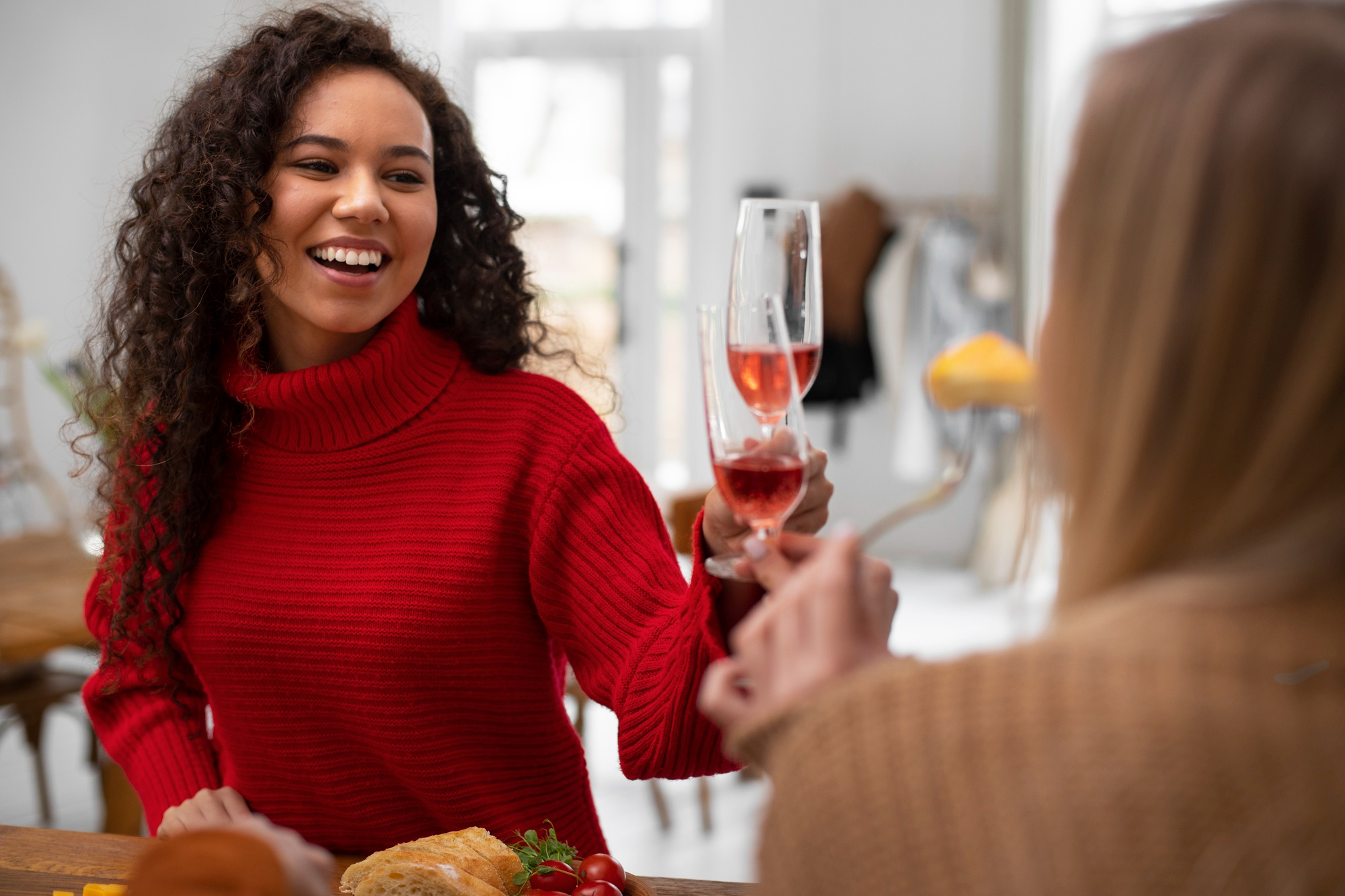 Two women laughing and drinking wine | Source: Freepik