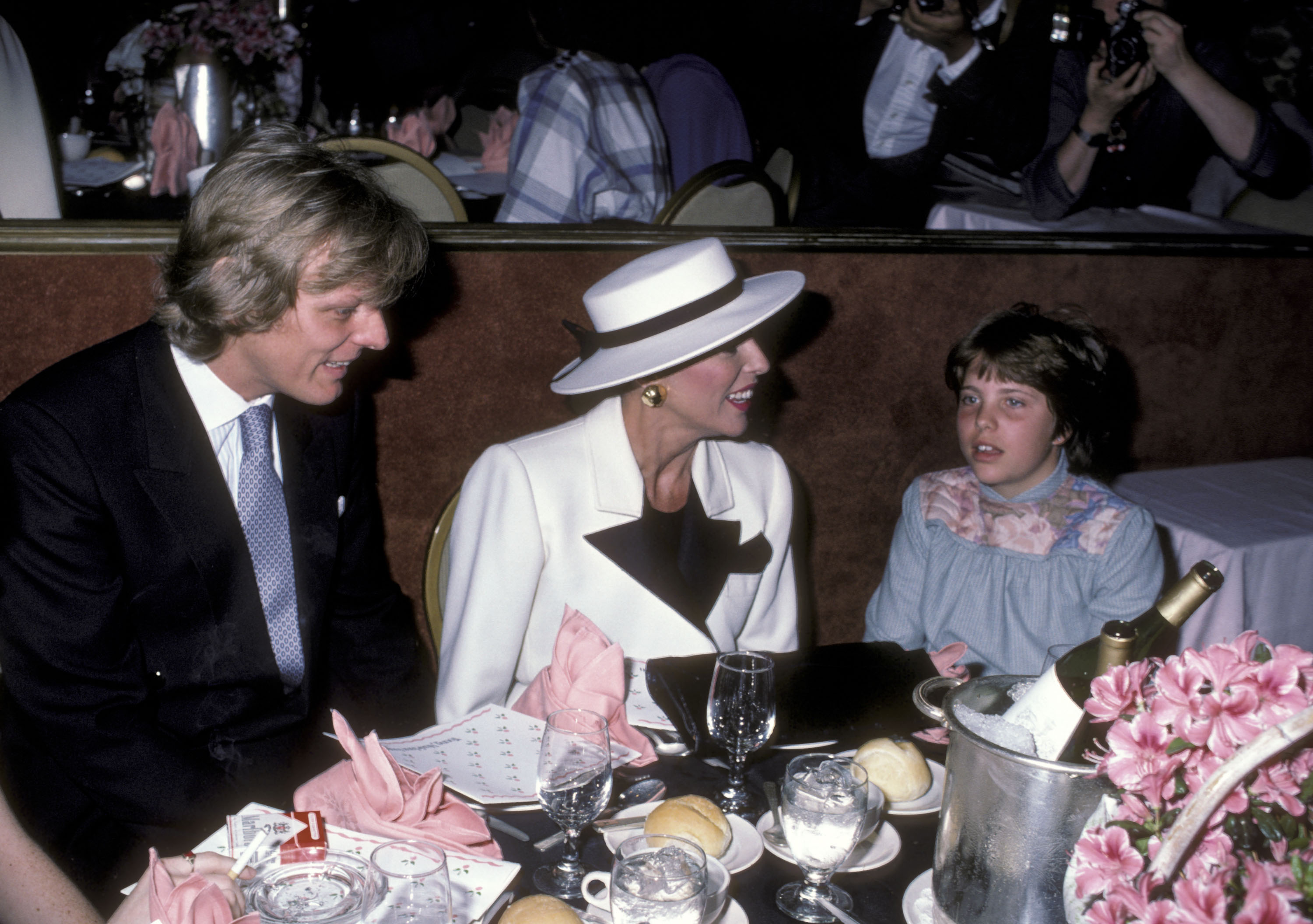 Joan Collins, Peter Holm and her daughter Katyana Kass during a Mother/Daughter Fashion Show on March 8, 1984 in Beverly Hills, California | Source: Getty Images