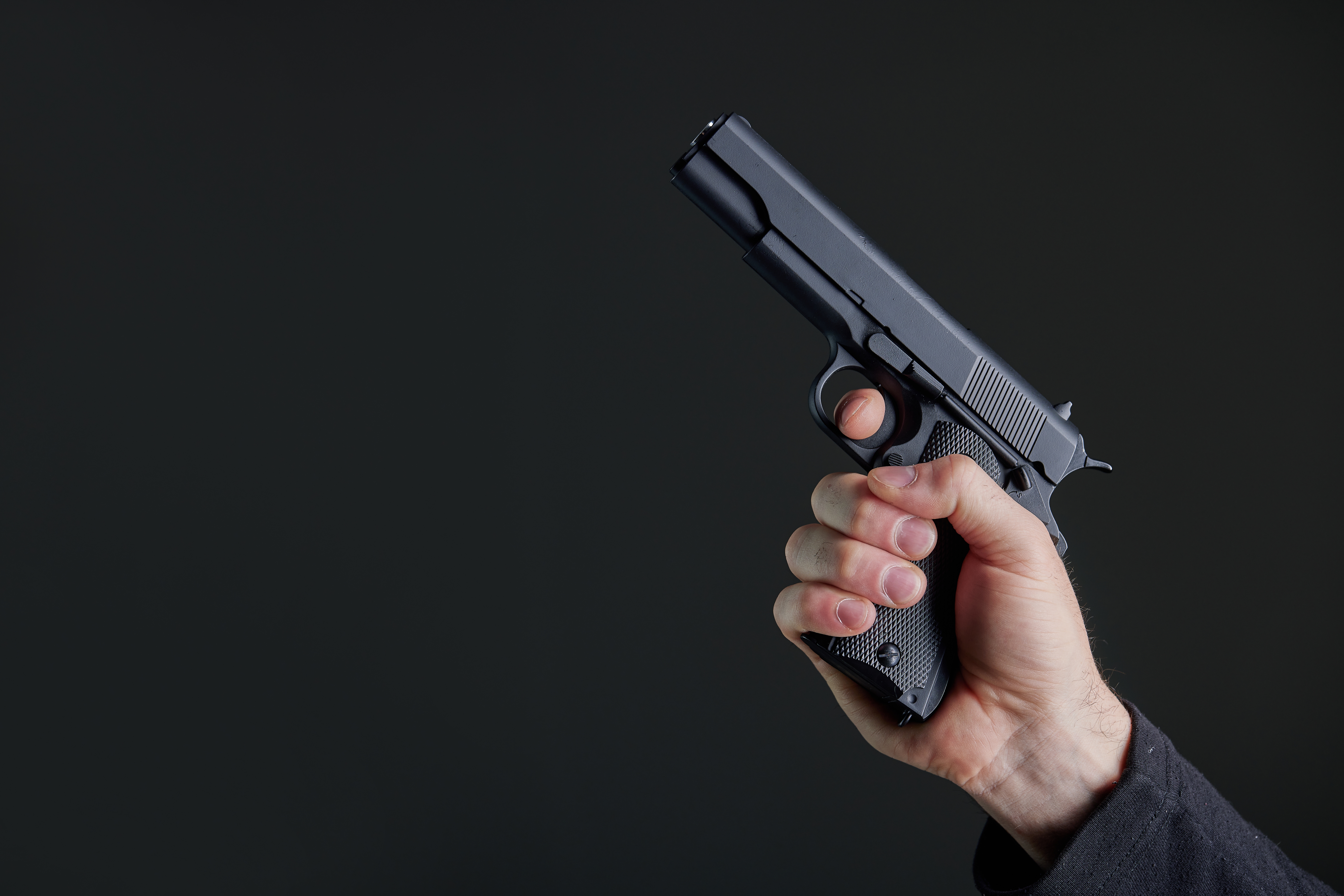 Male hand holding a gun | Source: Shutterstock