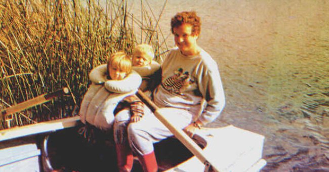 Una mujer y dos niños sentados sobre un bote en un lago. | Foto: Shutterstock