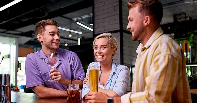 Two friends were sitting in their bar when a gorgeous young woman entered the bar. | Photo: Shutterstock