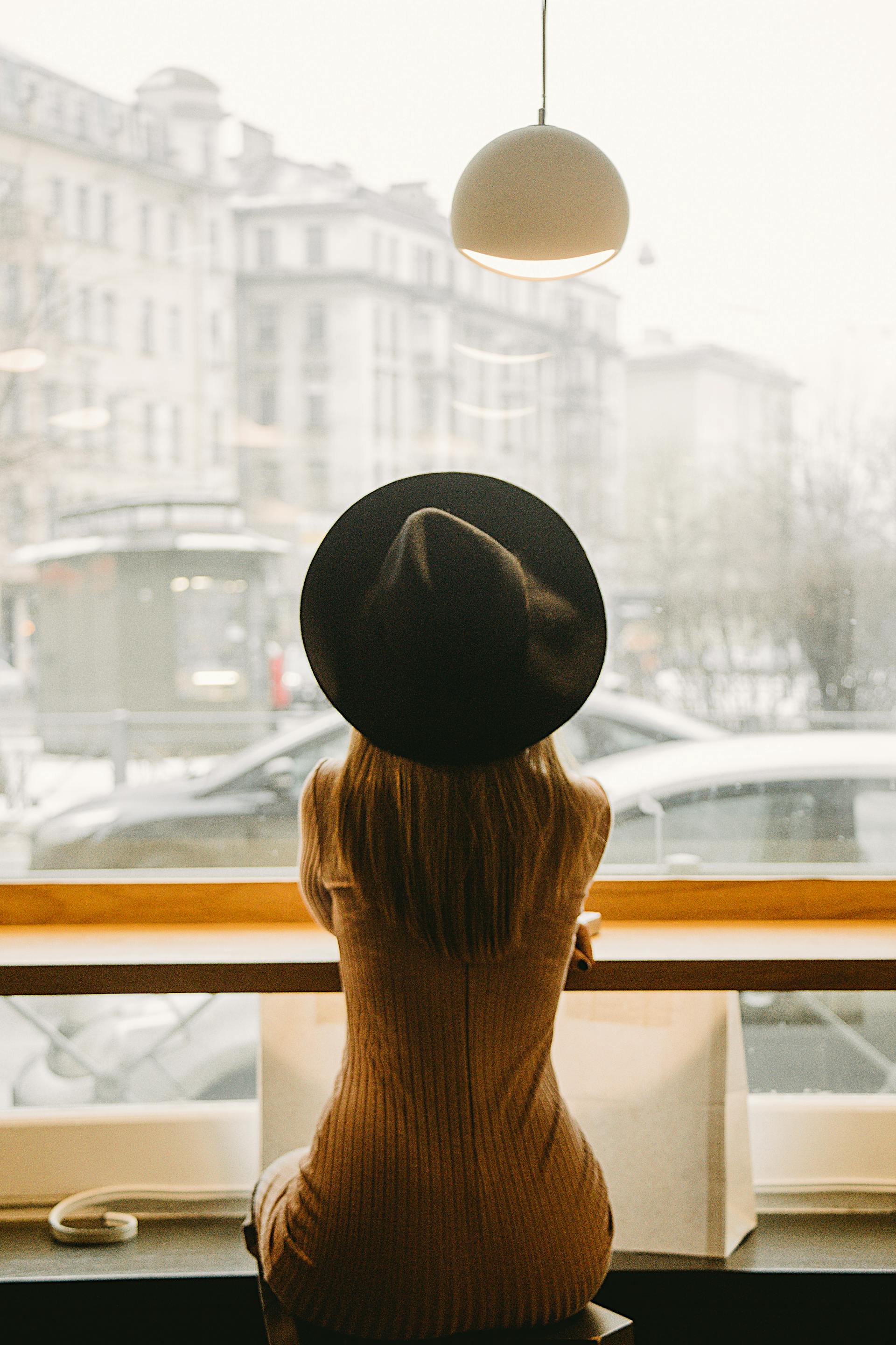 Woman looking outside a glass window | Source: Pexels