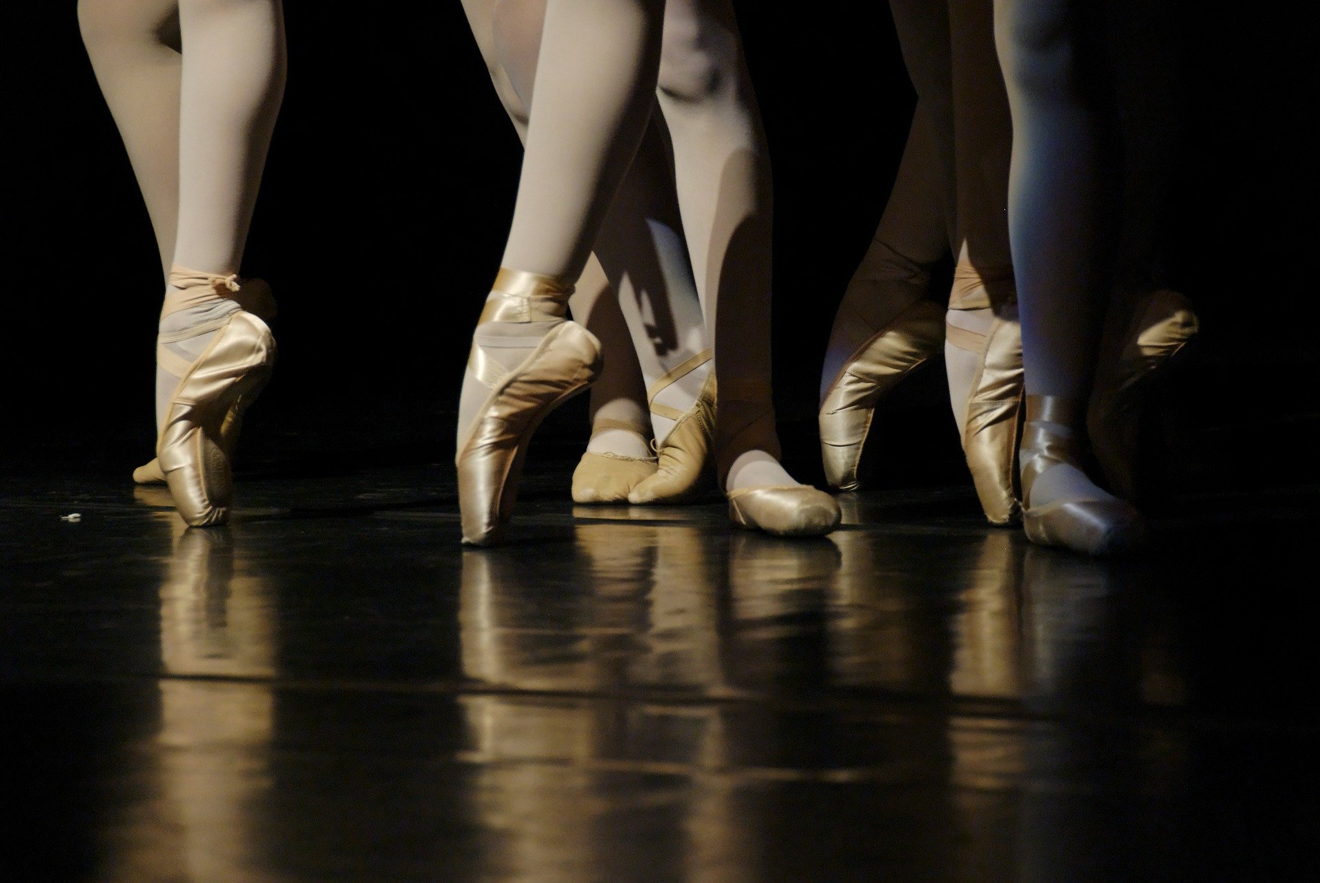 The legs and feet of several ballerinas standing together. | Source: Pixabay. 