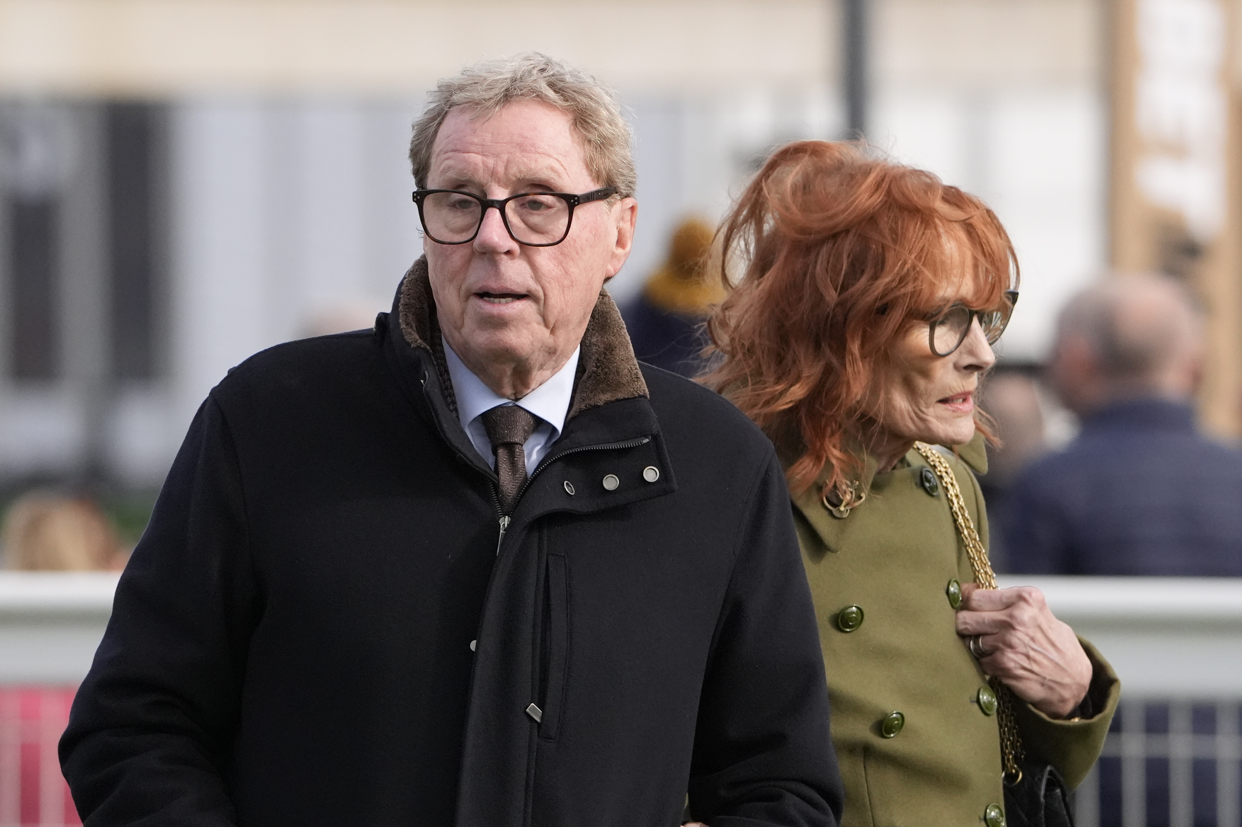 Harry and Sandra Redknapp were pictured at Cheltenham Racecourse on 11 March 2026 during Day 2 of the Cheltenham Festival, dressed for the cool conditions in tailored outerwear, the couple moving through the crowds with a quiet familiarity — a more understated public appearance that still reflected their long-standing presence together at racing events.