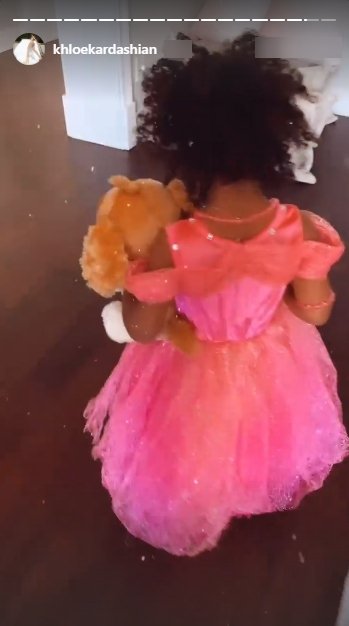 Khloe Kardashian’s daughter True holding a teddy bear whilst wearing a pink dress. | Source: Instagram/khloekardashian 