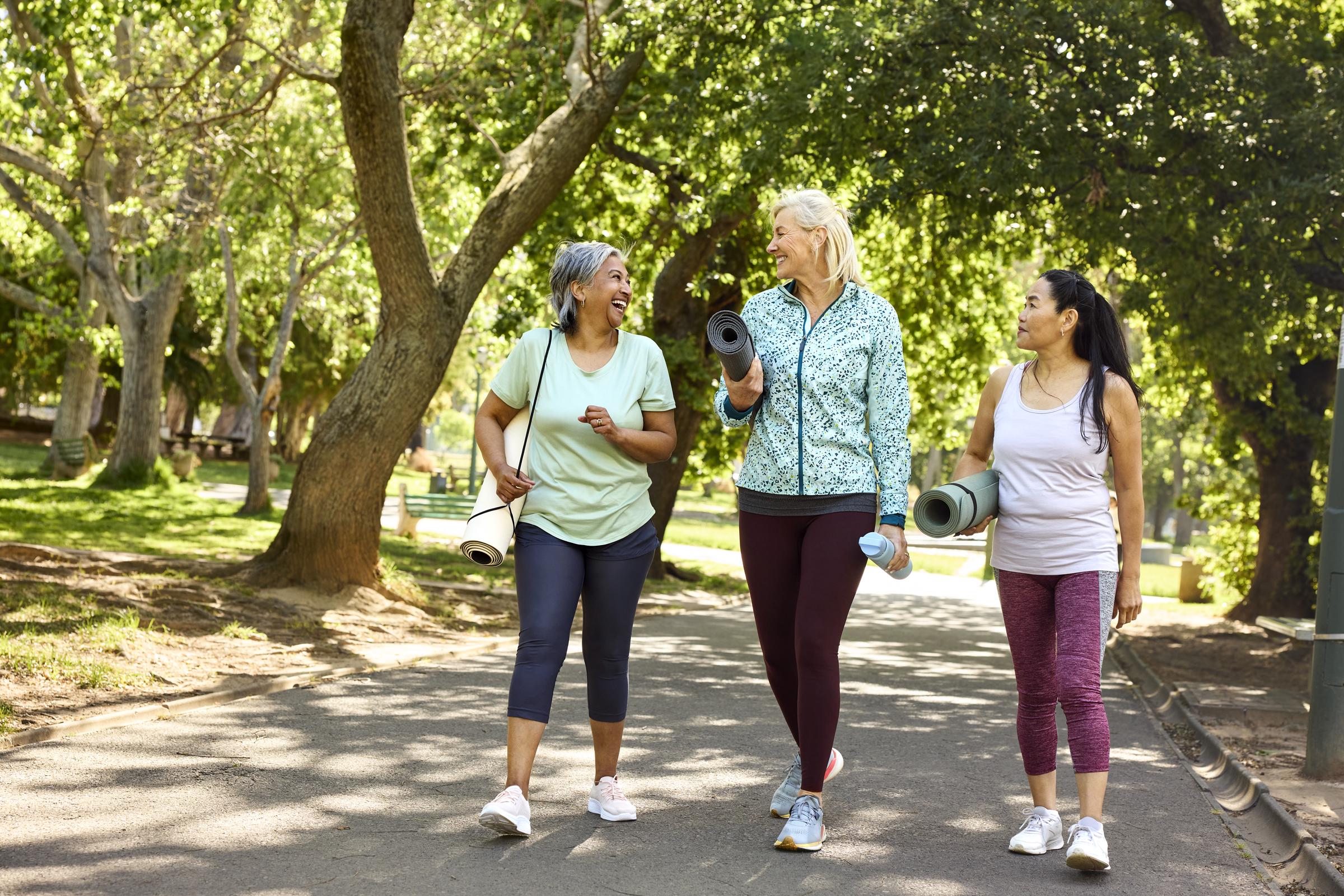 A group of women walking with their exercise mats in a park | Source: Getty Images