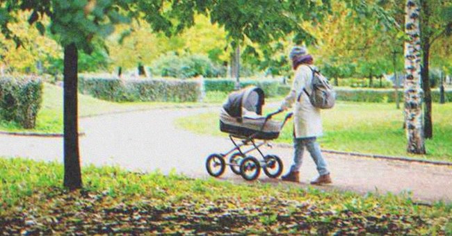 A woman pushing a stroller through a park | Source: Shutterstock