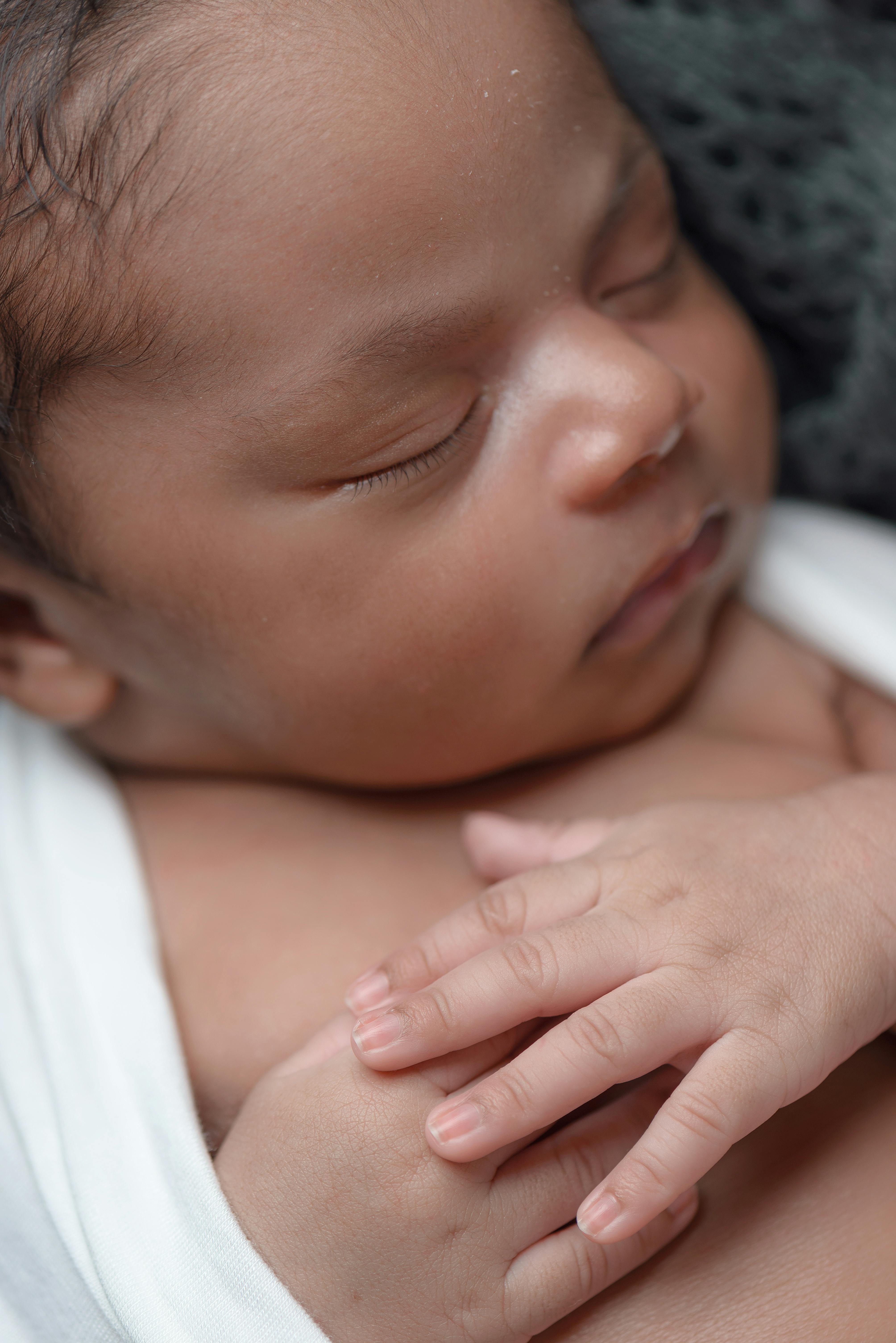 A baby sleeping while covered in coat | Source: Pexels