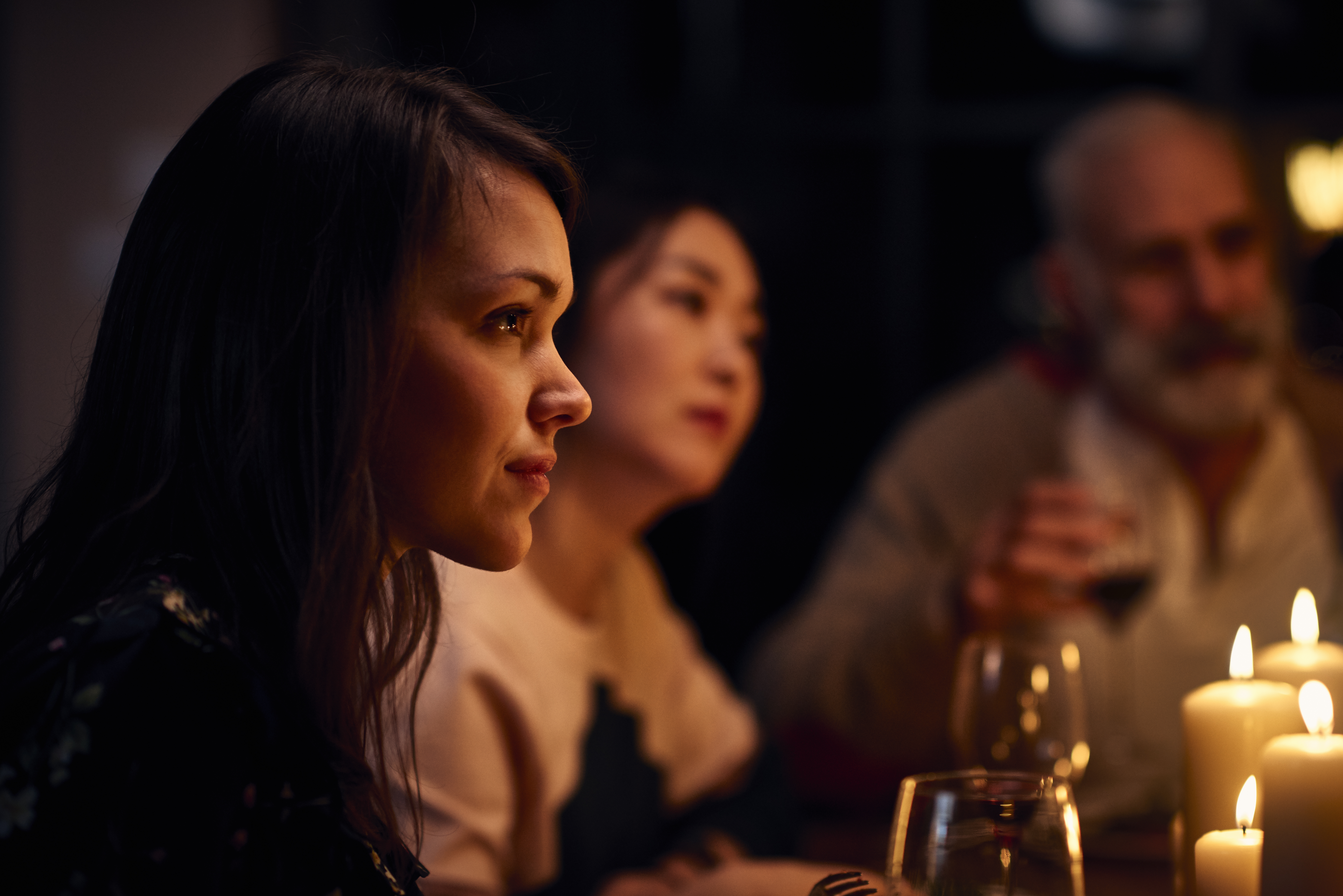 Serene looking woman at dinner party listening attentively | Source: Getty Images