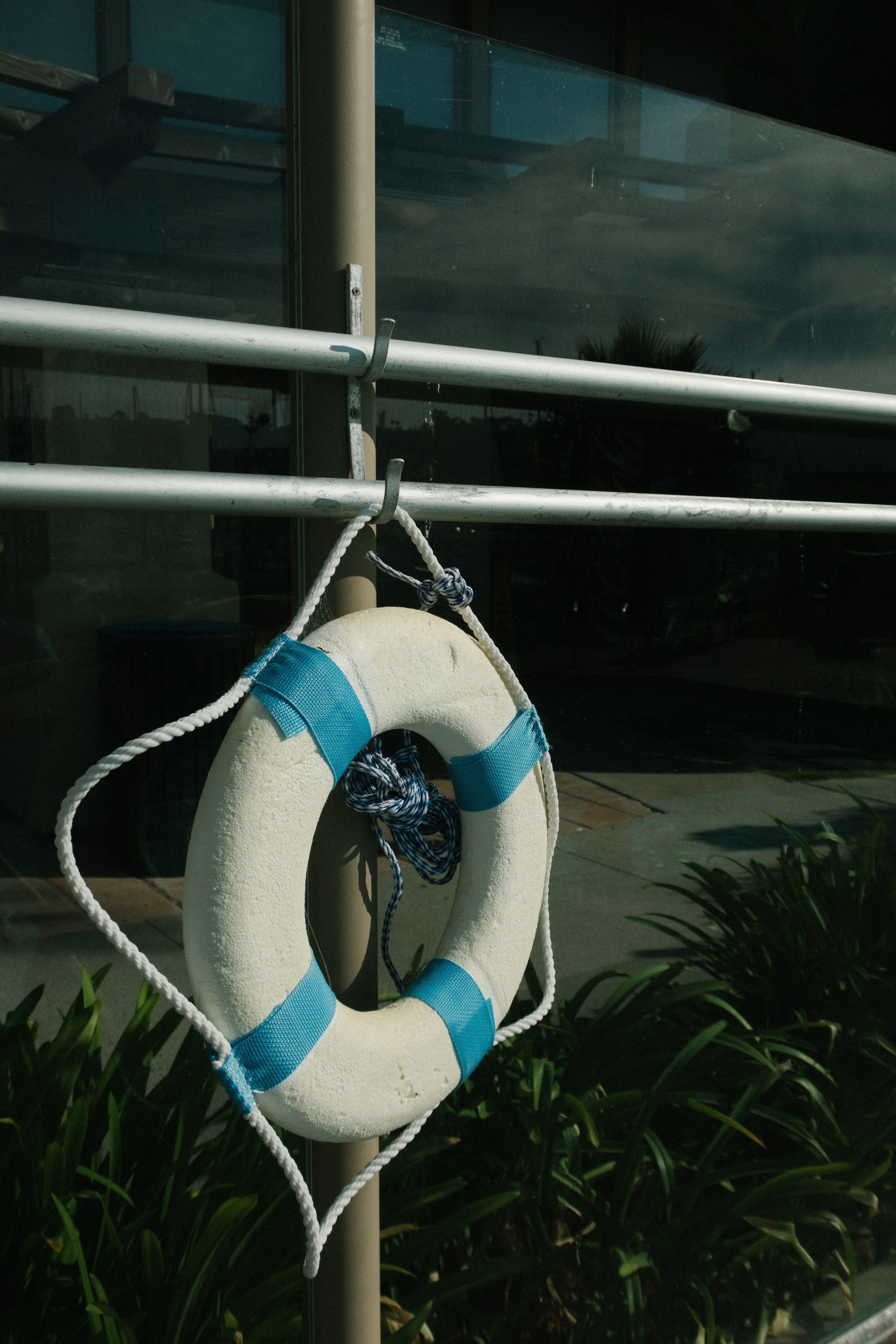 Blue and white life saver buoy attached to a pole. | Pexels/ Athena 