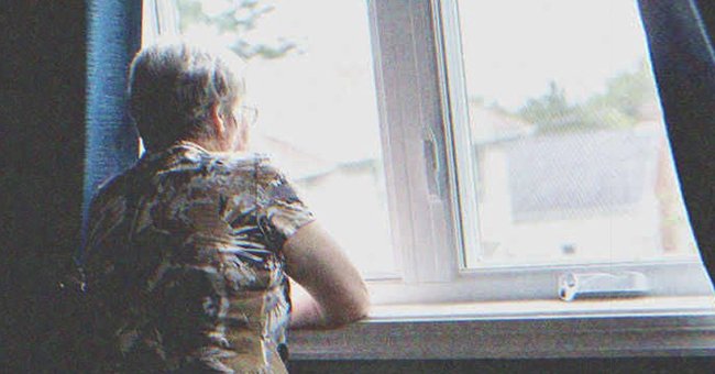 An old lady looking out a window | Source: Shutterstock