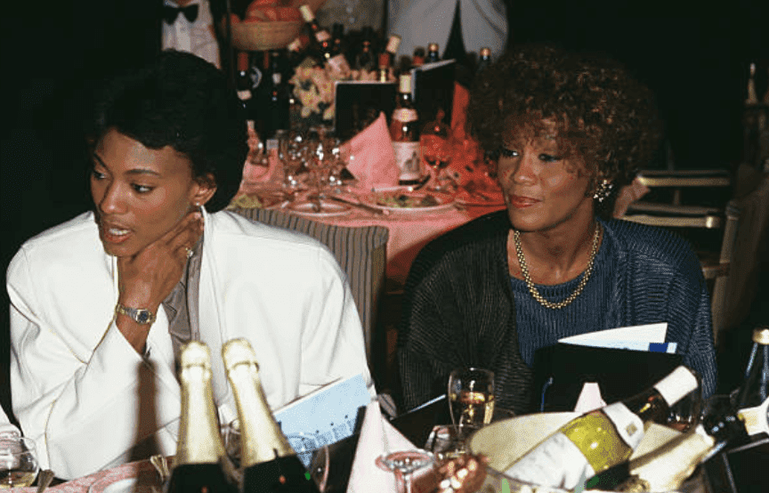 Robyn Crawford Whitney Houston dine at an event with tables decked out with champagne bottles, on January 01 1988 | Source: Dave Hogan/Getty Images