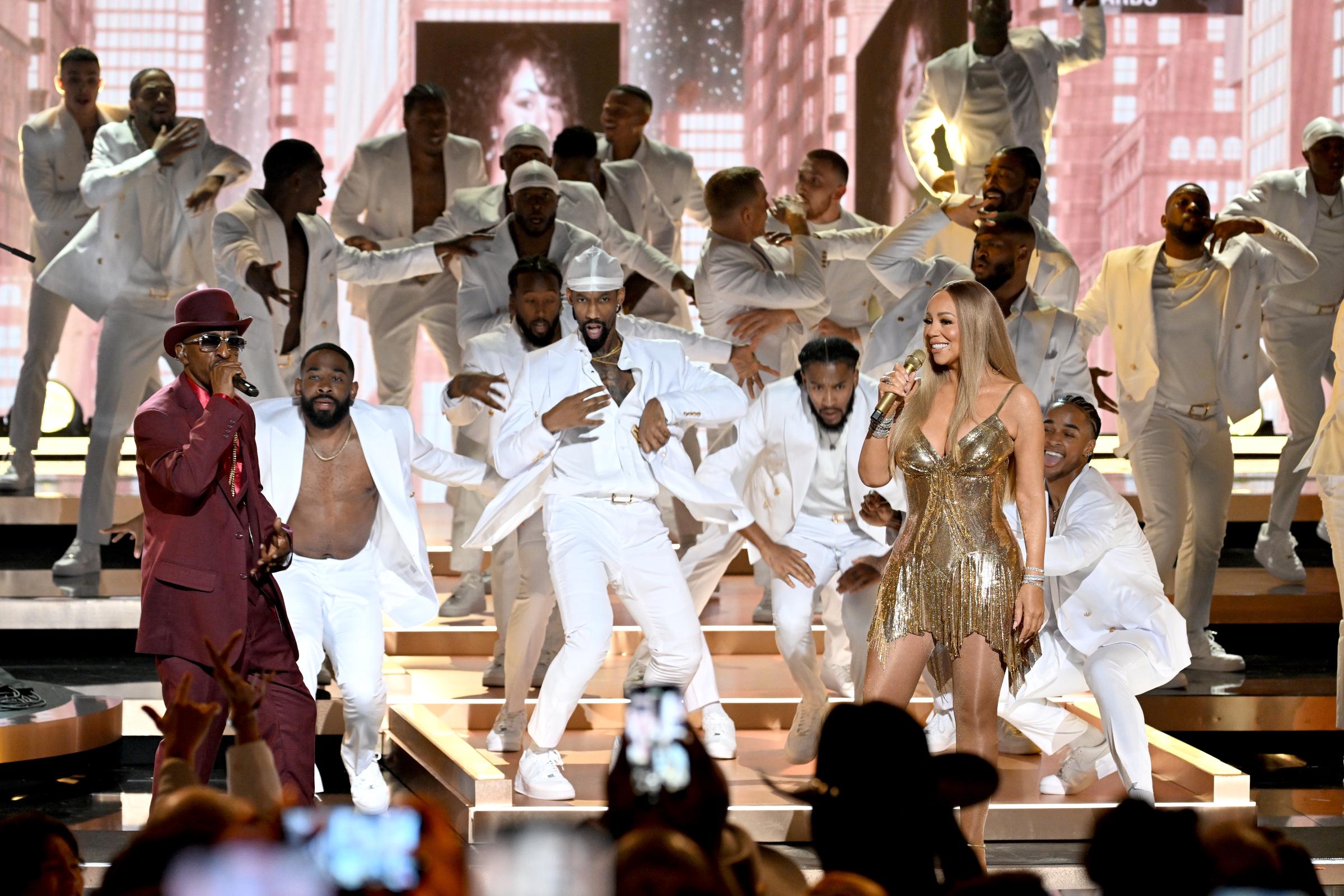 A sight to behold, the image captures nearly everyone on stage immersed in the performance. Limbs bend in fluid dance, while Rakim and Carey focus on the audience, hands raised high, clearly reveling in the moment.