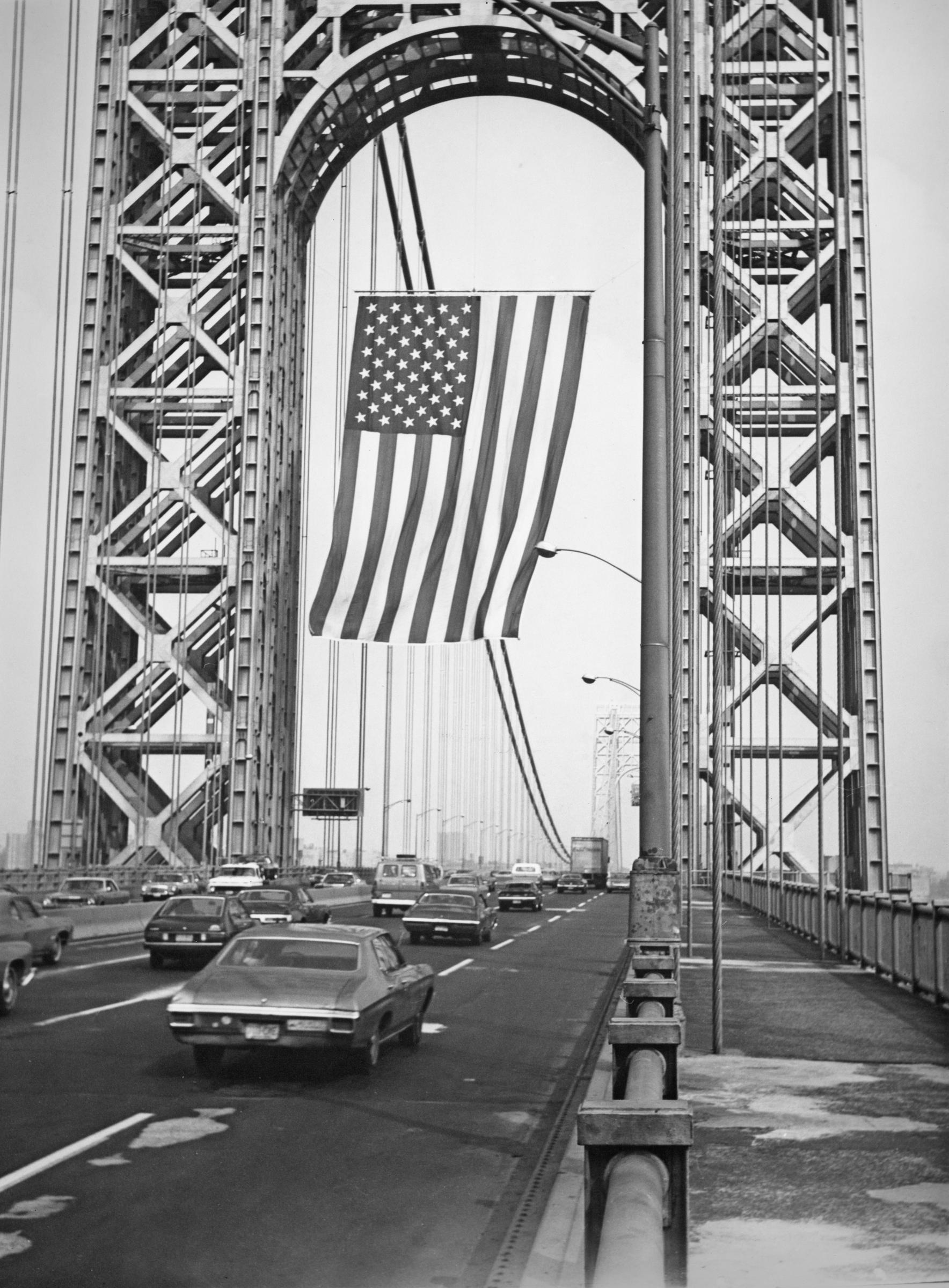 The largest free-flying flag in the United States, measuring 60 feet by 90 feet, photographed hanging from the George Washington Bridge, spanning the Hudson River in 1976. | Source: Getty Images