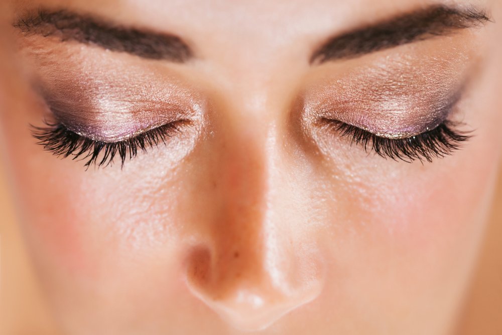 Mujer usando una sombra base brillante en sus párpados. | Foto: Shutterstock