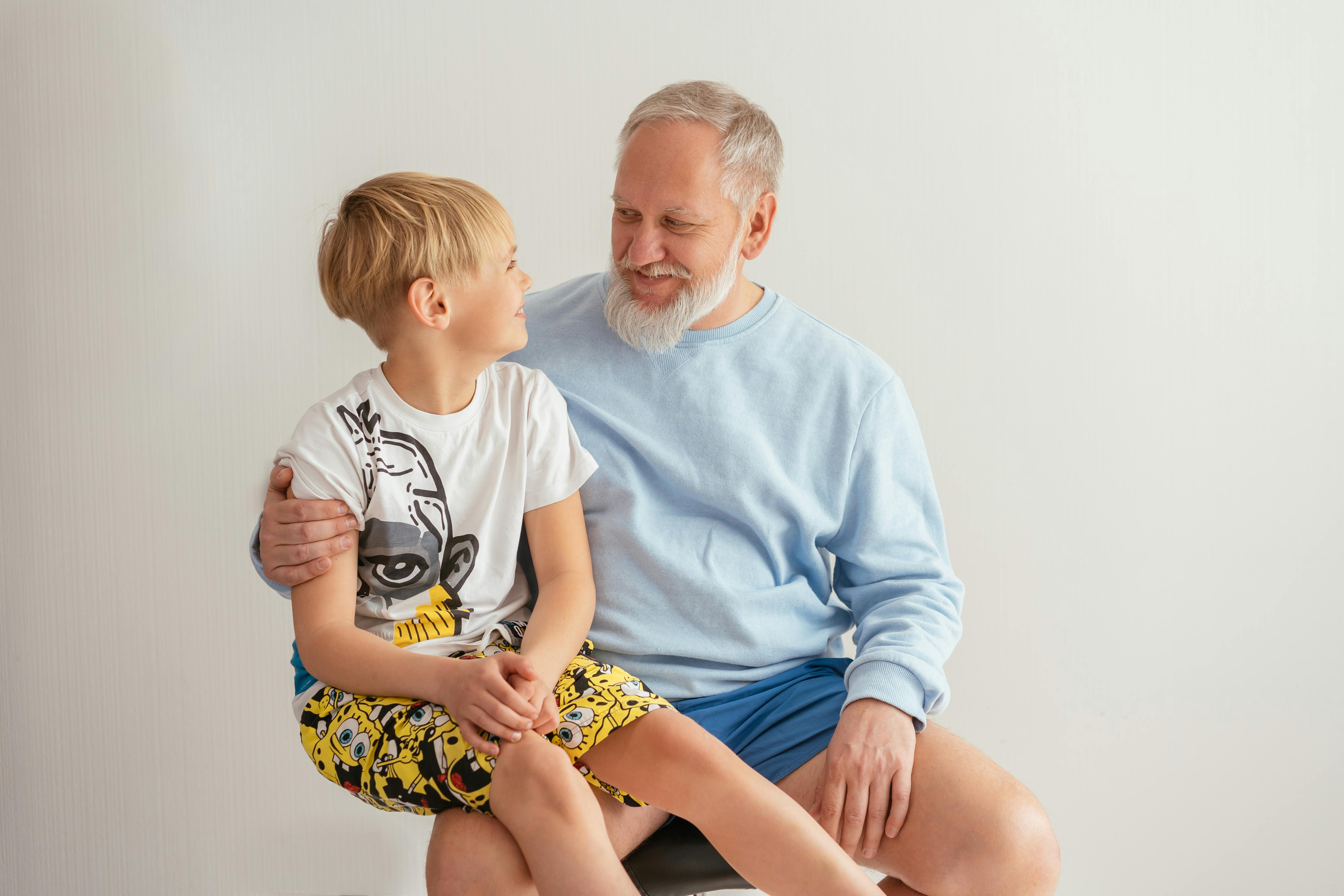Young boy sitting on his grandfather's lap | Source: Pexels