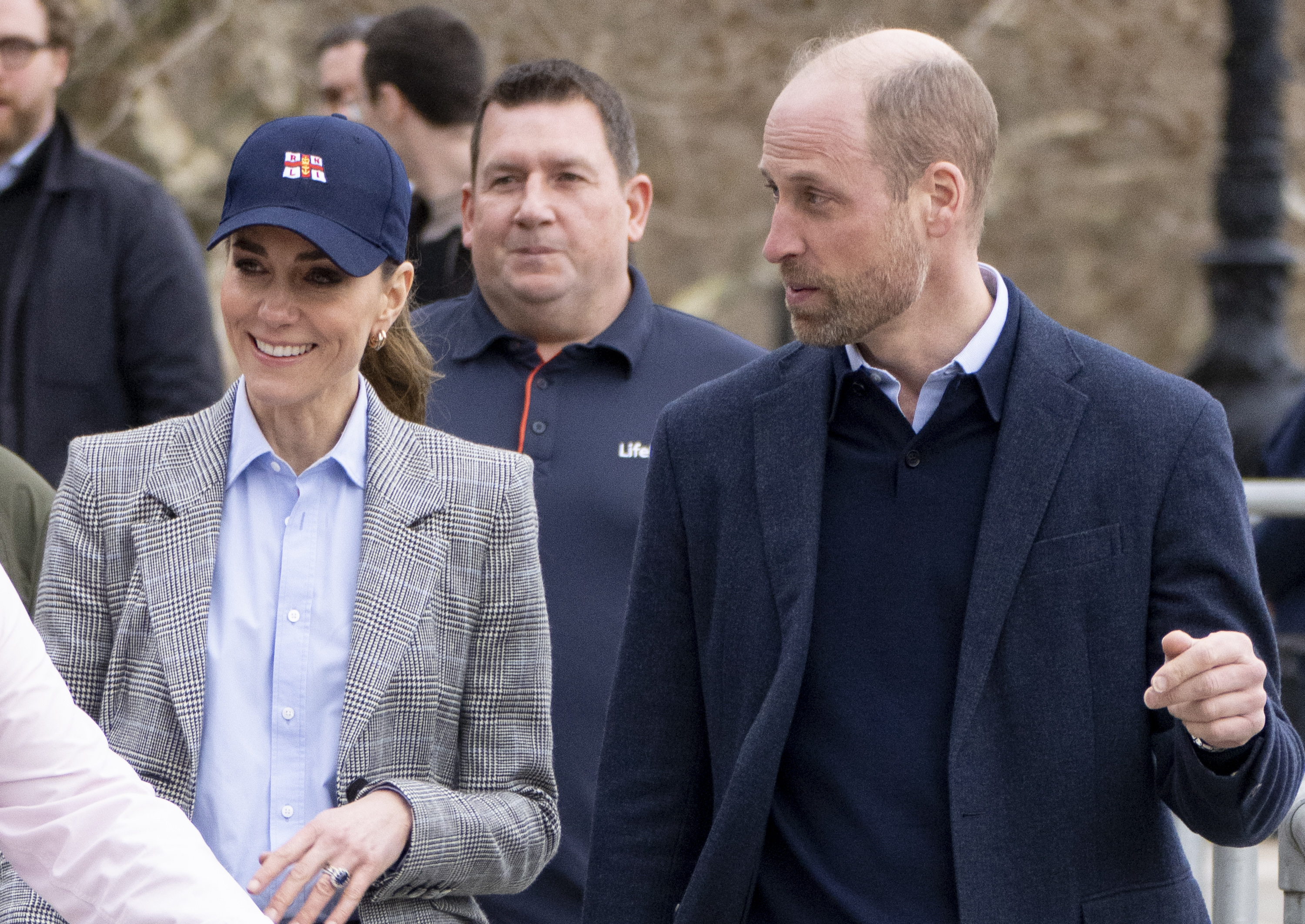 Smiling and side by side, the Prince and Princess of Wales make their way through the crowds outside the RNLI Tower Station on 12 March 2026, the Princess still sporting her navy RNLI cap. For the couple, who launched a lifeboat together at an RNLI station in Anglesey just two months before their 2011 wedding, the visit was a return to a place that holds a particular spot in the story of how their public life together began.