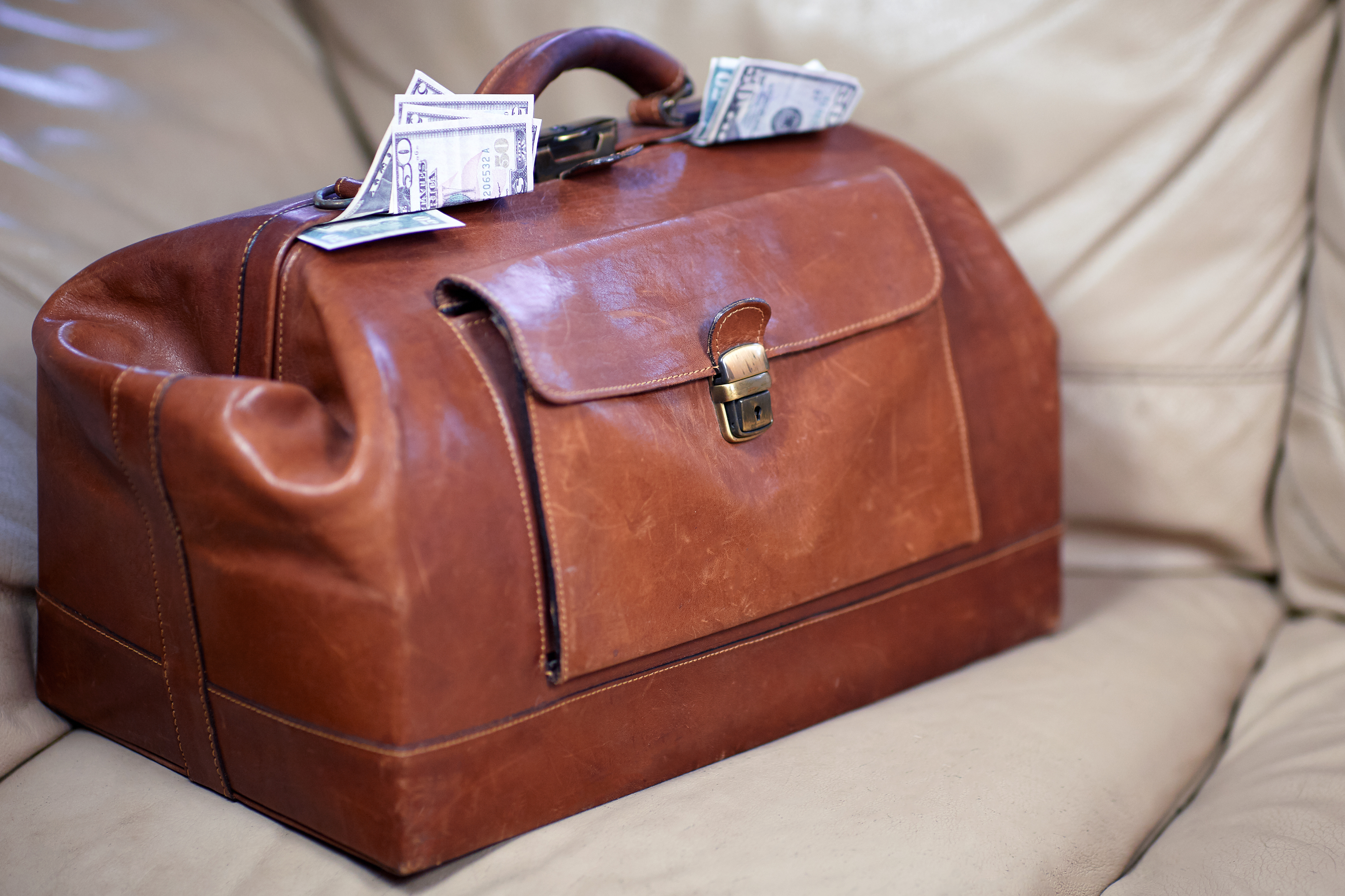 Old vintage red leather case full of money | Source: Shutterstock