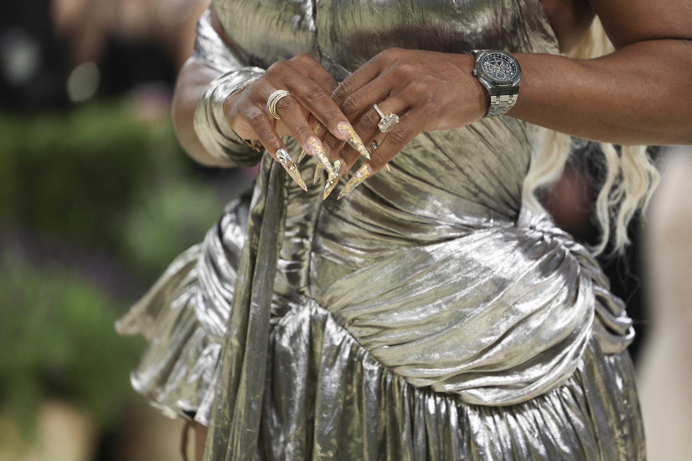A close-up shows Serena Williams' metallic dress details and accessories at the 2026 Met Gala | Source: Getty Images
