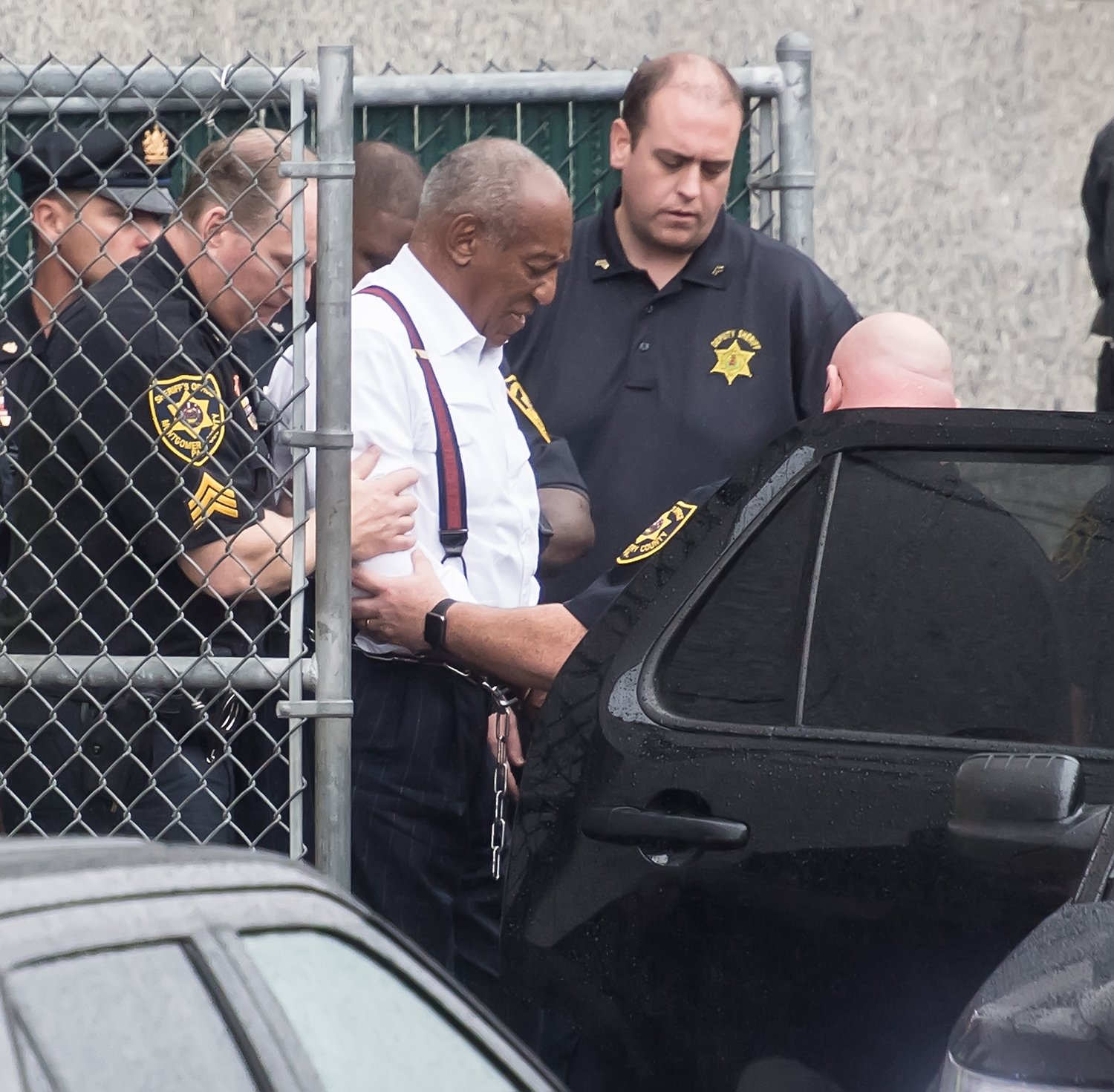 Comedian Bill Cosby being led into a vehicle wearing handcuffs | Photo: Getty Images