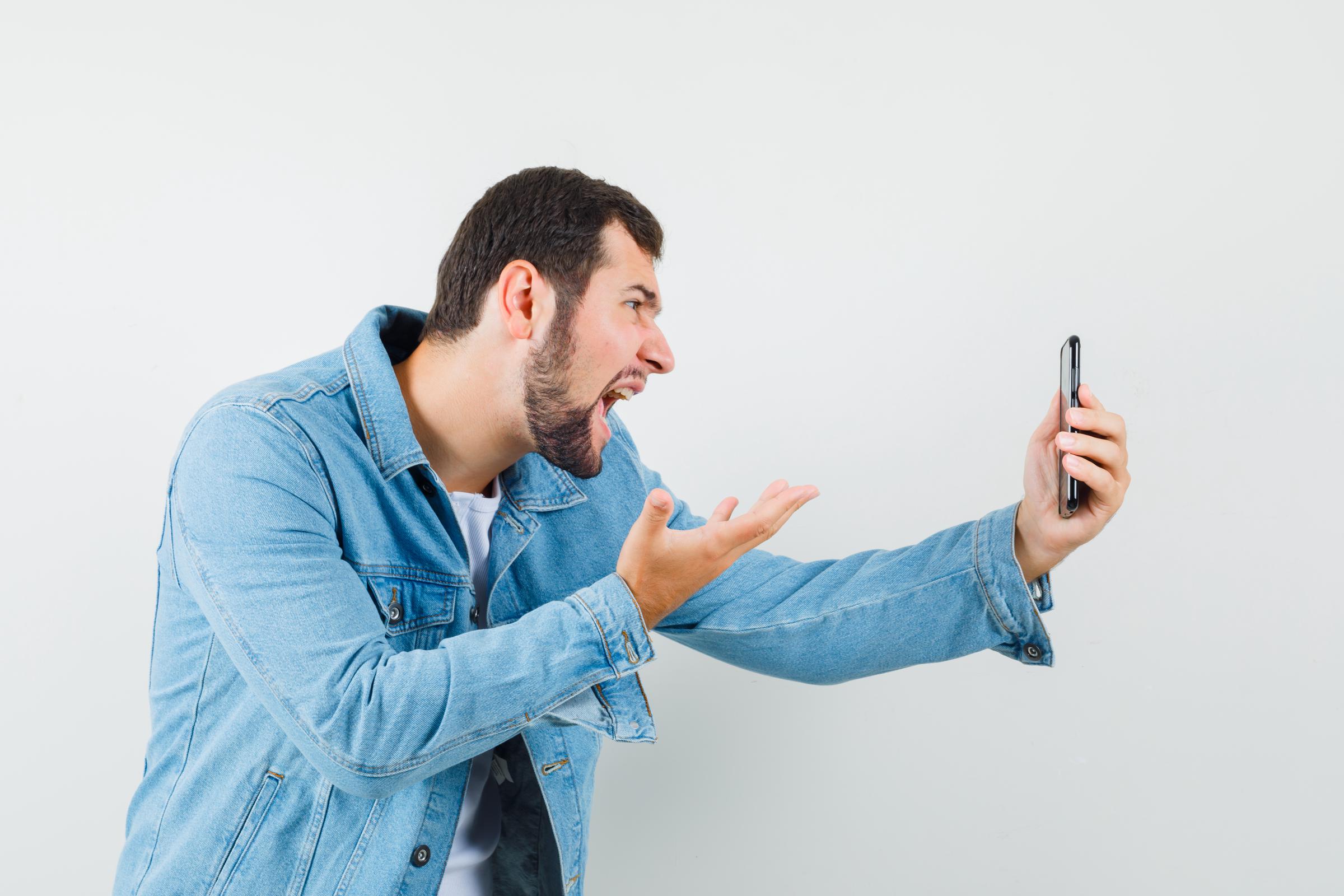 An agitated man talking on the phone | Source: Freepik