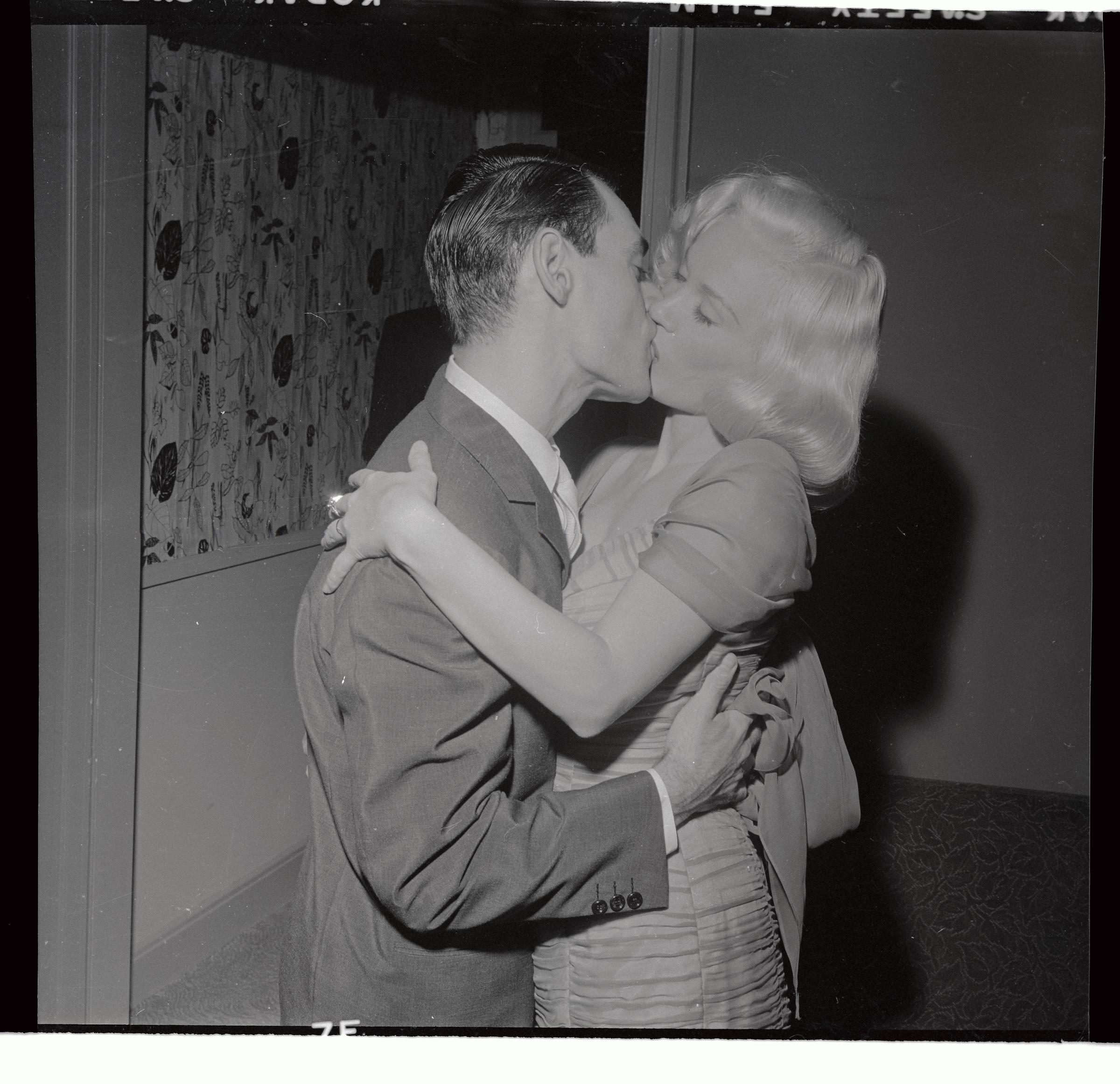 The famous blonde star photographed sharing a kiss with orchestra leader and her husband at the time, Ray Anthony, in 1955. | Source: Getty Images