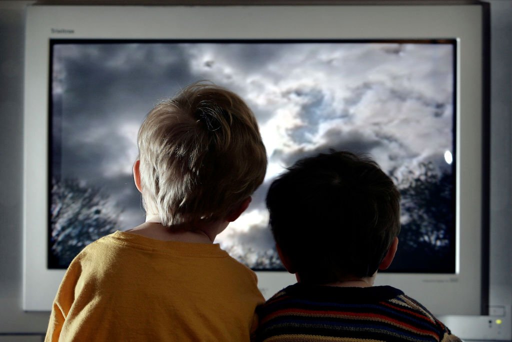Des enfants en train de régader la télé. | Photo : Getty Images