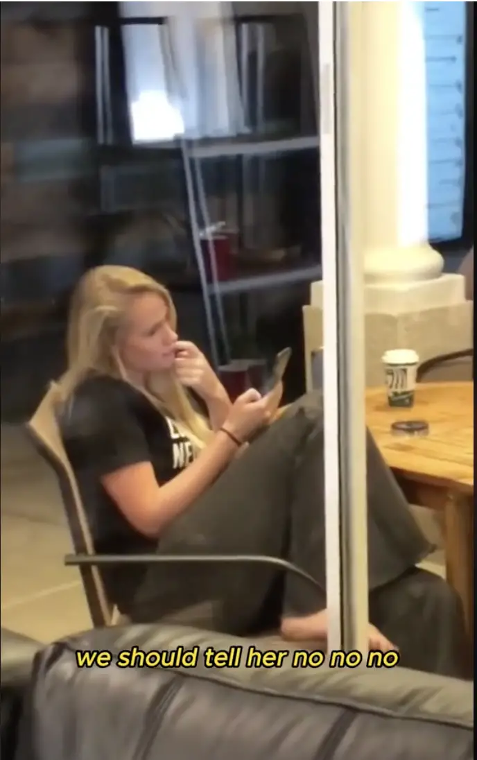Woman sitting outside checking her phone while the rest of her friends are inside | Source: TikTok/loviewa