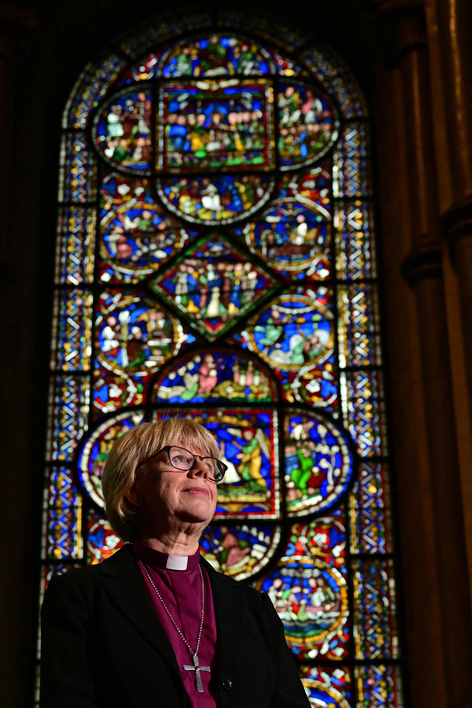 Dame Sarah Mullally photographed in The Corona Chapel at Canterbury Cathedral on 3 October 2025, shortly after the announcement of her appointment as the 106th Archbishop of Canterbury. Behind her, the chapel's ancient stained glass windows have looked down on 105 archbishops before her — all of them men.