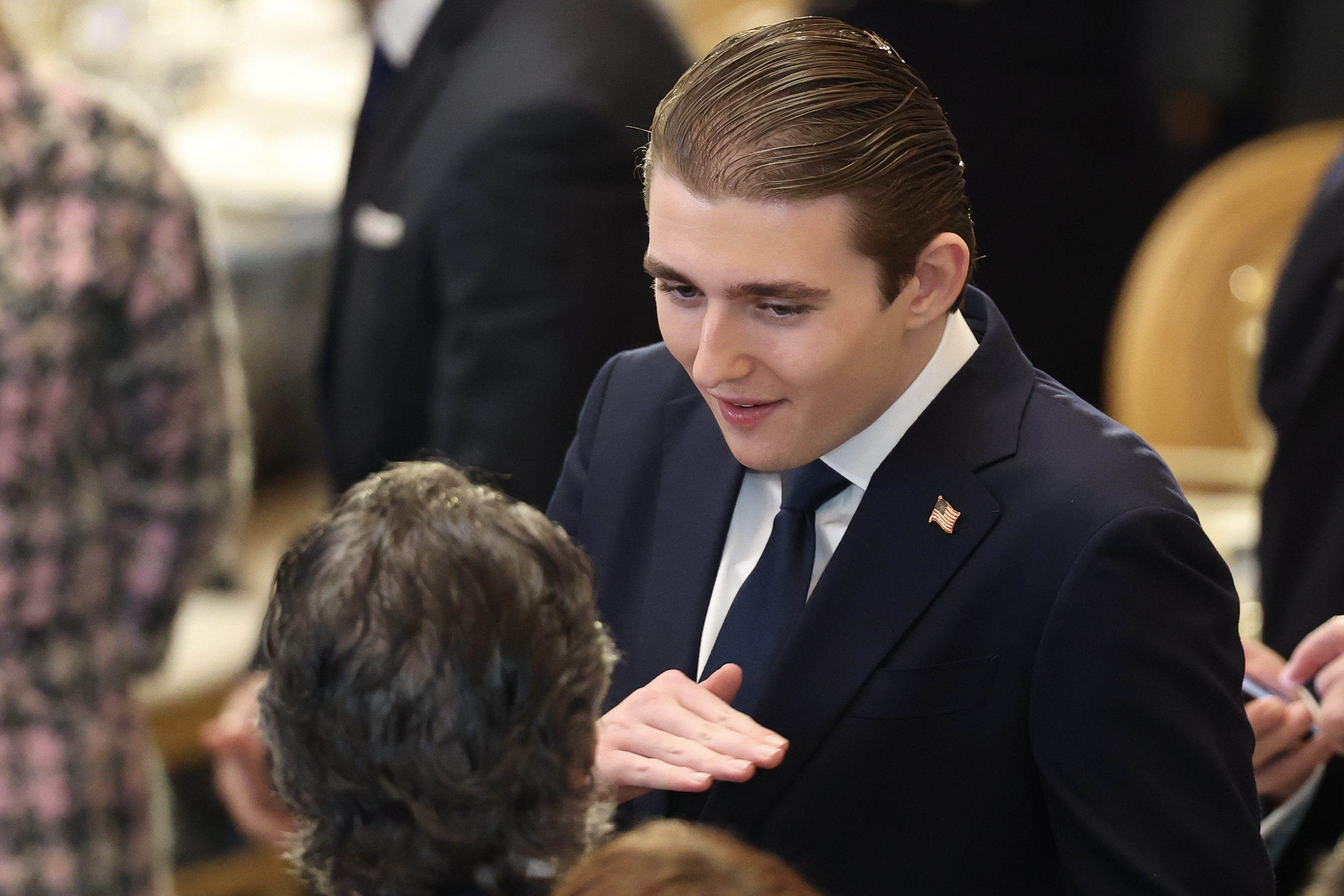 Barron Trump speaking with an attendee at his father's inaugural luncheon. | Source: Getty Images