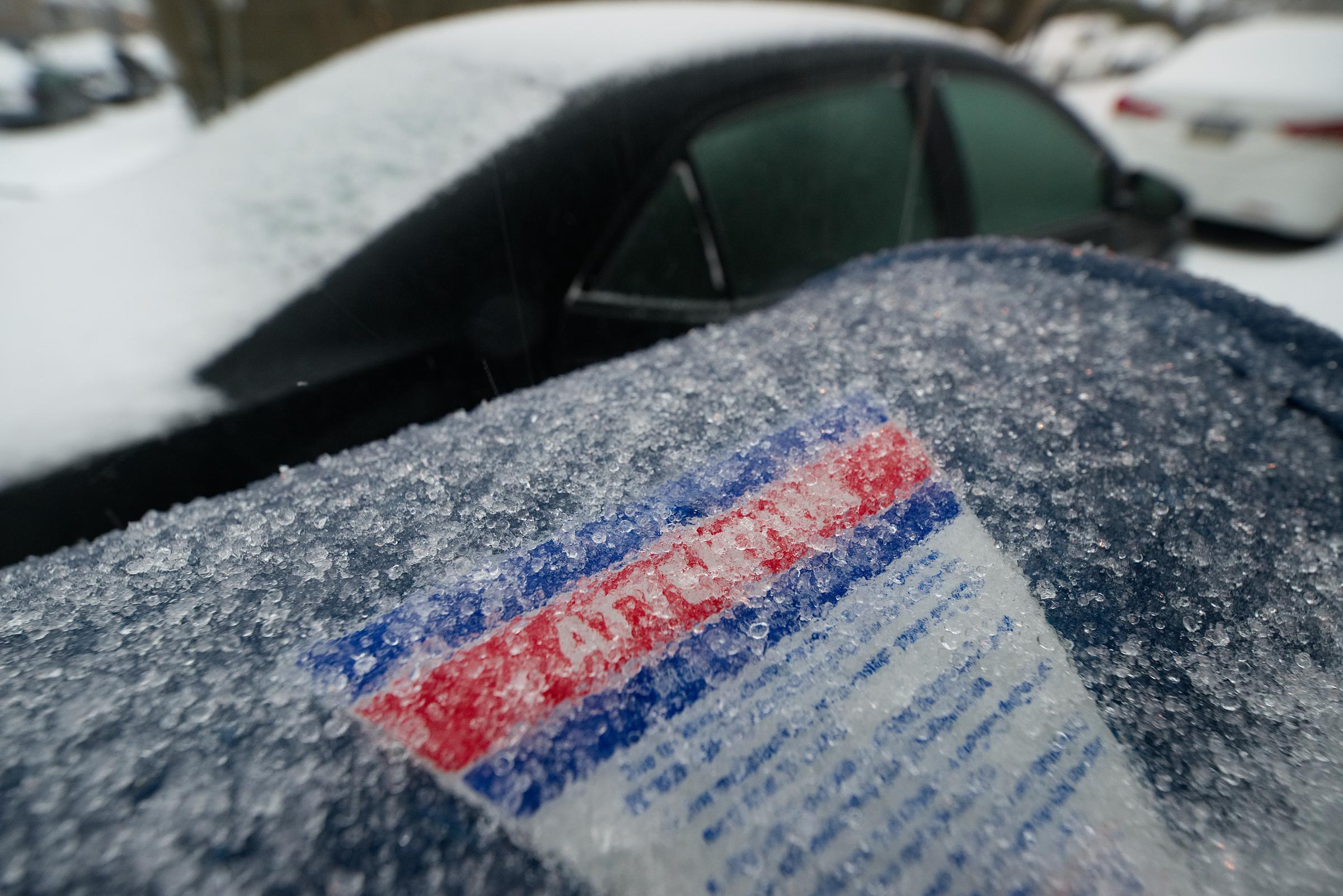 A mailbox coated in ice with icy cars in the background | Source: Getty Images