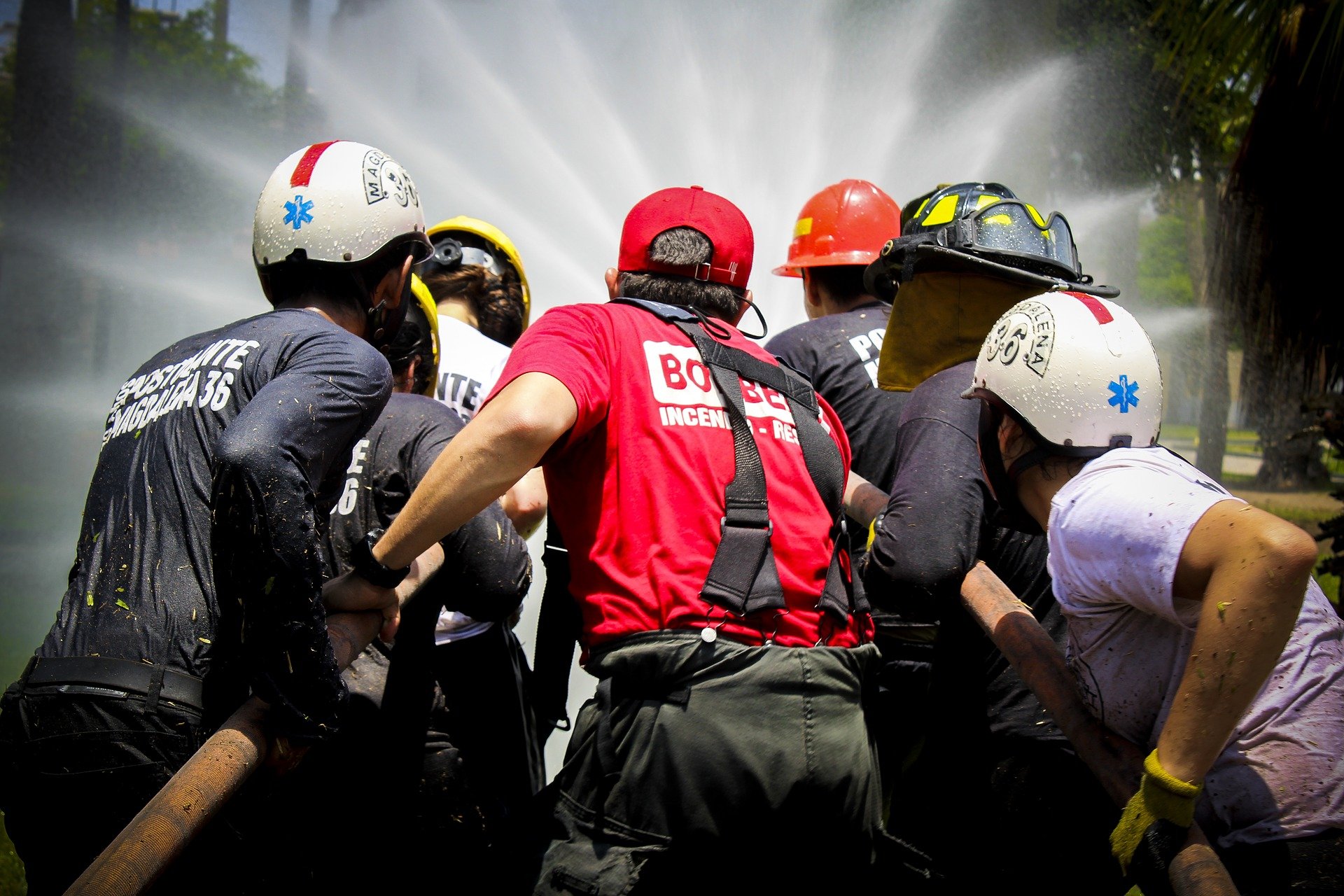 Pictured - An image of fire and water rescue teams wearing helmets and pulling a hose | Source: Pixabay 