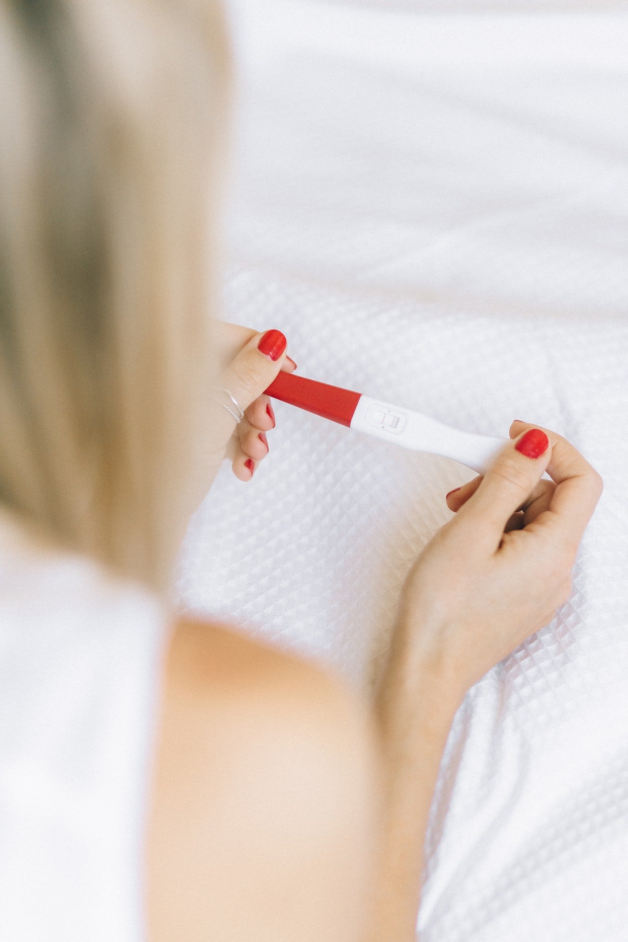 Mujer sosteniendo test de embarazo. | Foto: Pexels