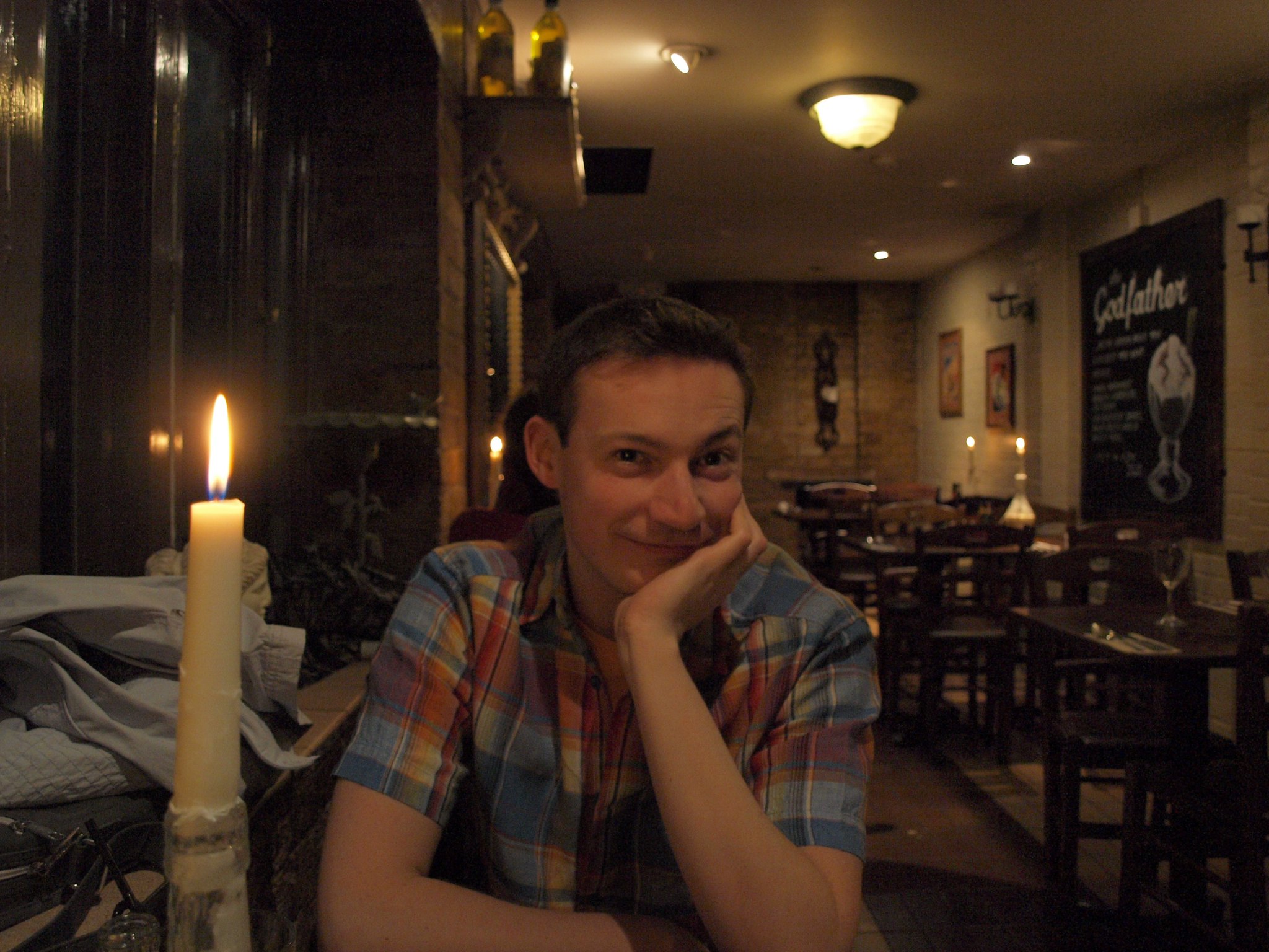 A man smiling and looking happy while having his picture taken at a restaurant | Source: Flickr