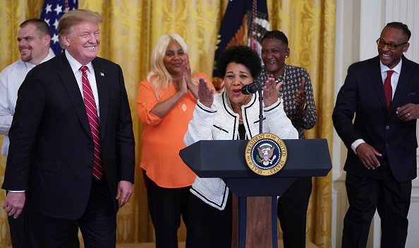 Alice Marie Johnson, who had her sentence commuted by U.S. President Donald Trump (L) after serving 21 years in prison for cocaine trafficking, thanks the press during a celebration of the First Step Act in the East Room of the White House April 01, 2019, in Washington, DC. | Source: Getty Images.