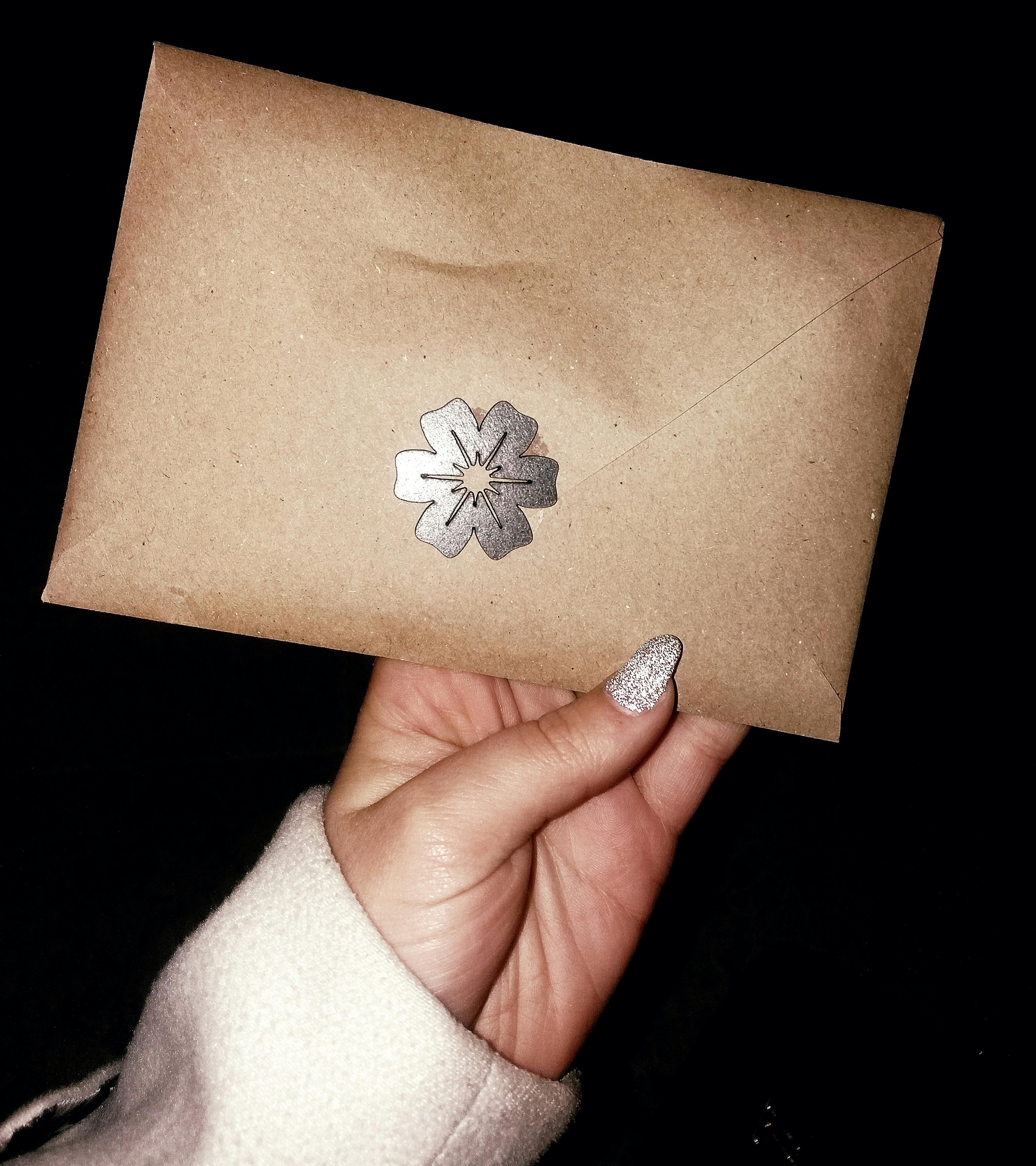 A woman's hand holding an envelope | Source: Pexels