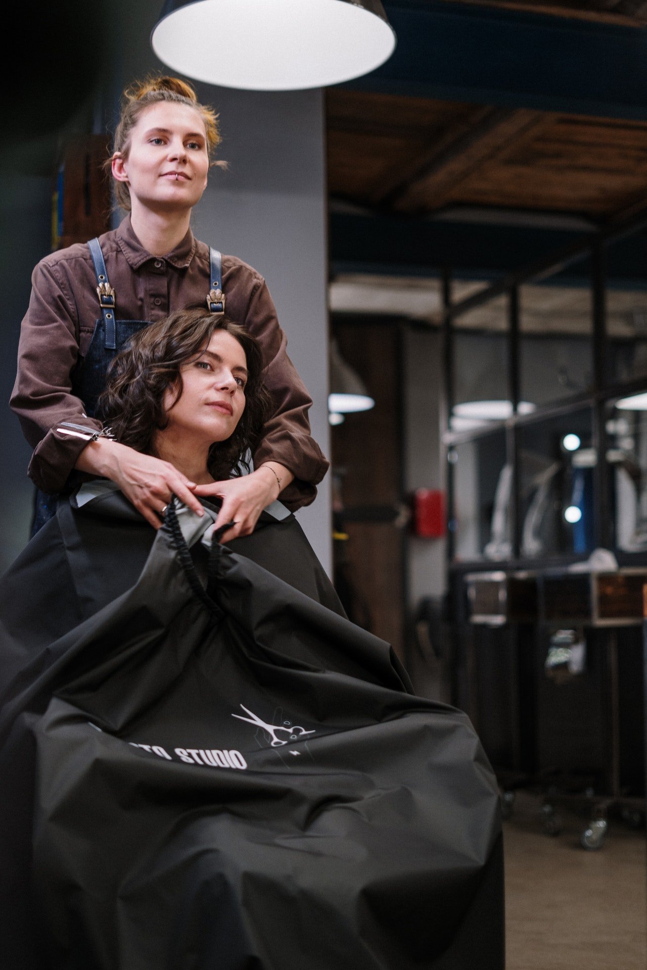 Hairdresser working on woman's hair | Photo: Pexels
