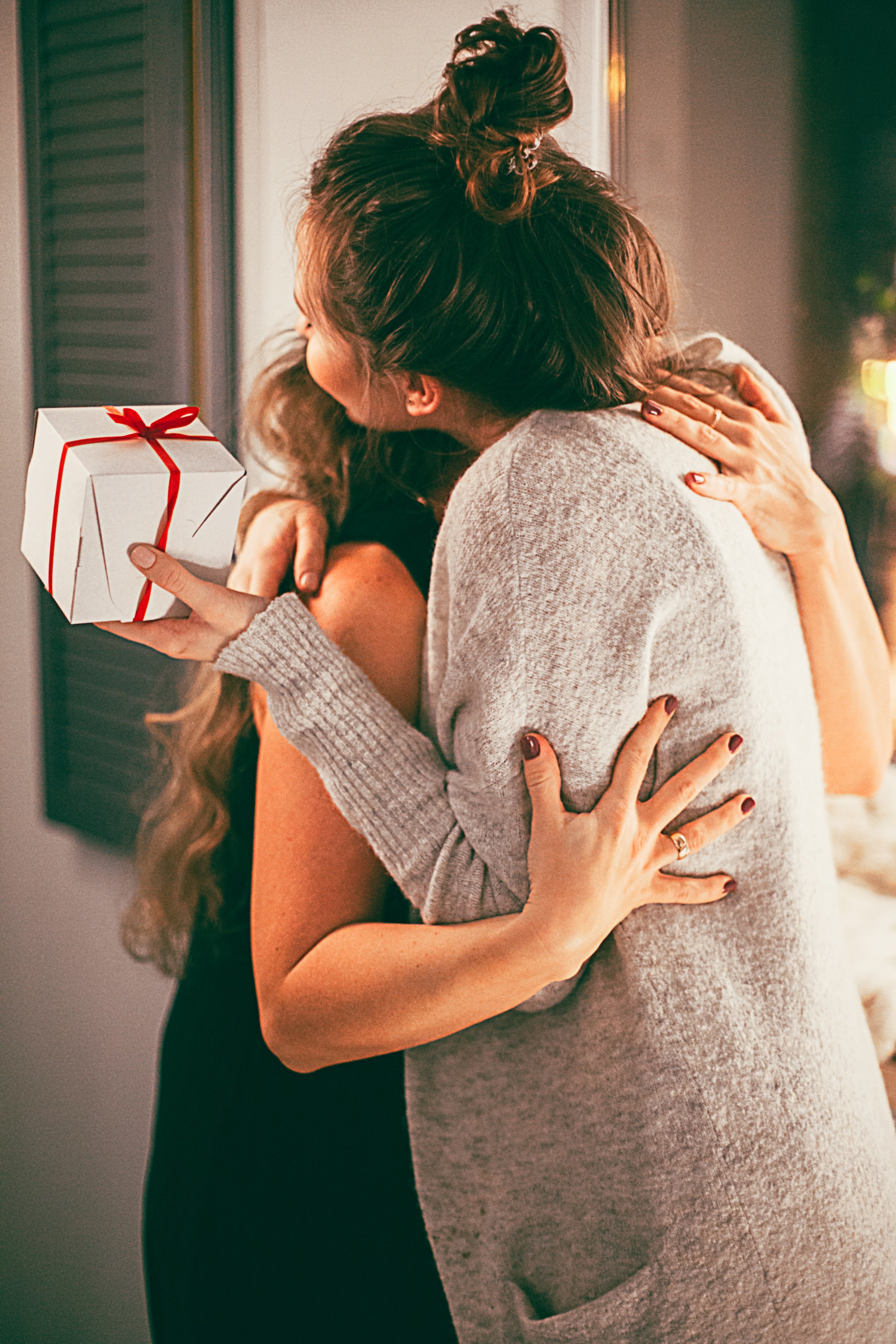 Two women embracing each other with gifts. | Source: Pixabay