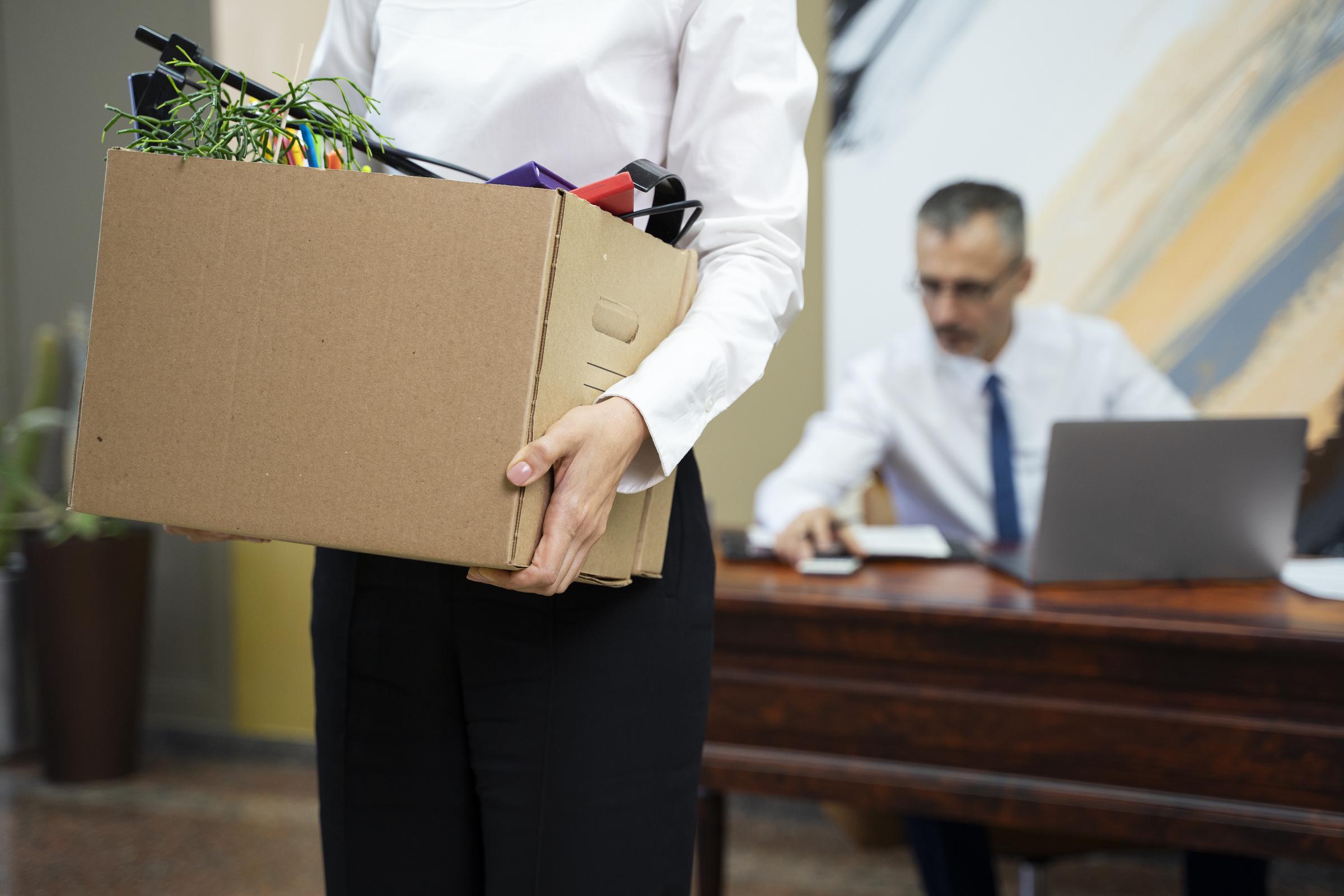 A woman carrying a box after being fired | Source: Freepik