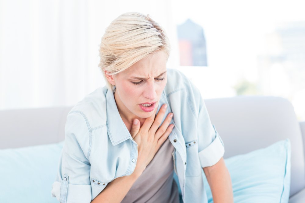 Mujer rubia con dificultades para respirar. Fuente: Shutterstock